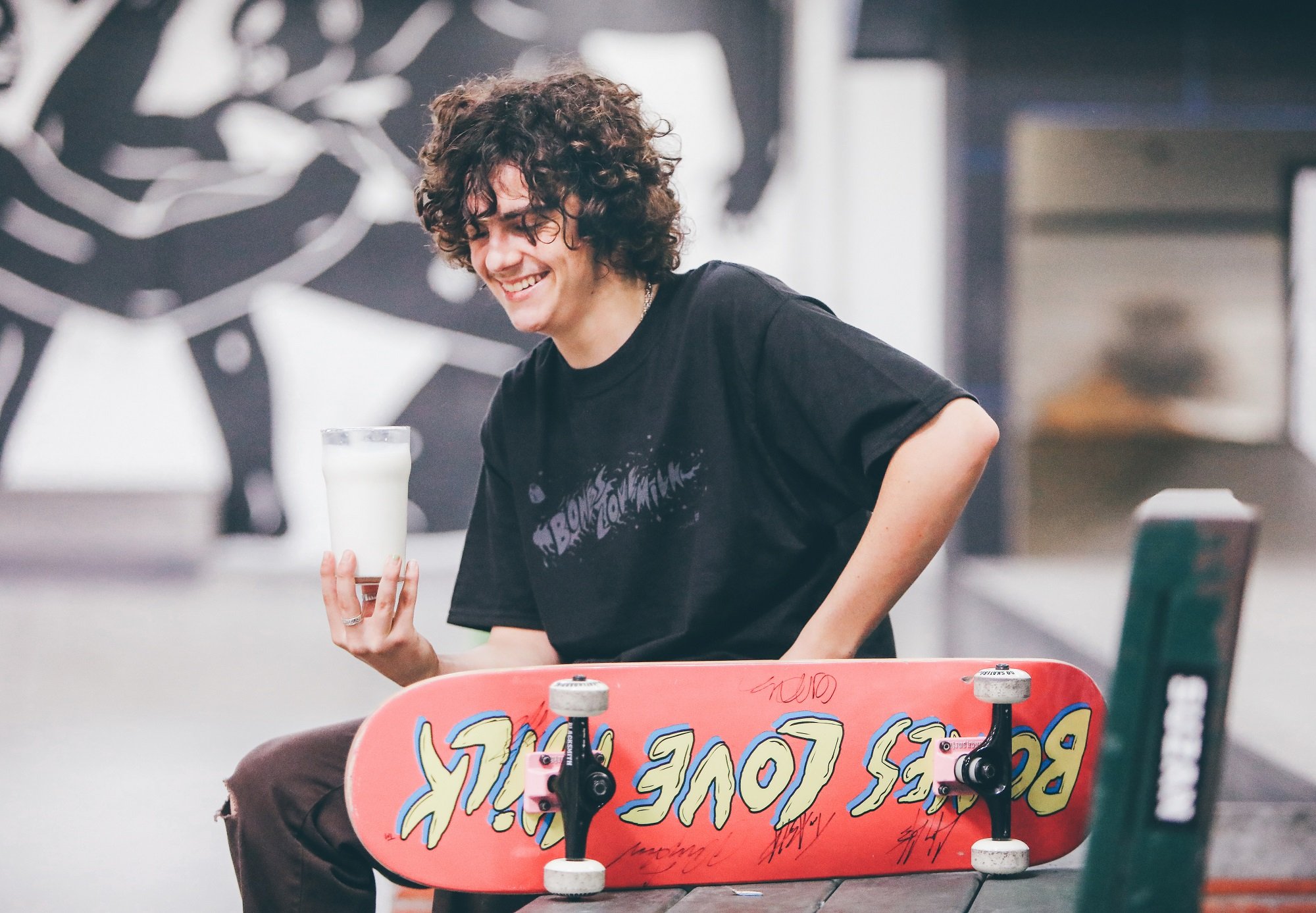 Jack Dylan Grazer holds a glass of milk and a skateboard