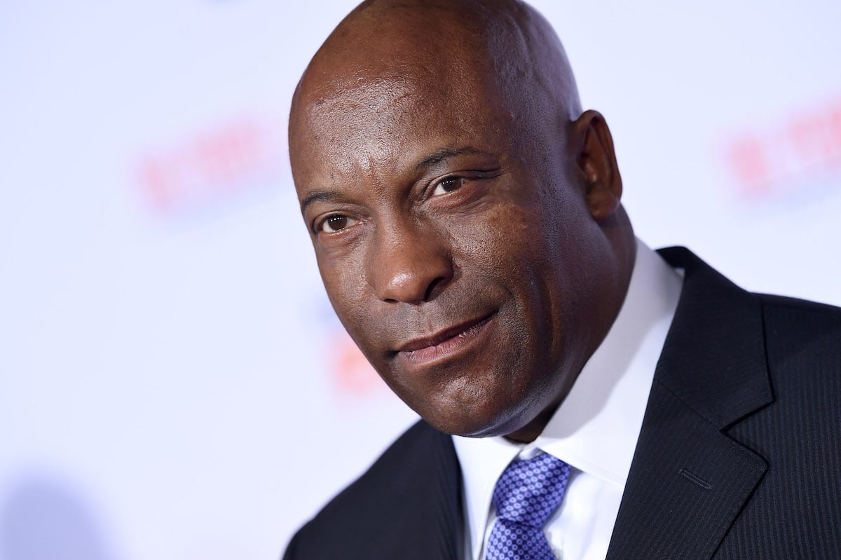 John Singleton wears a suit and tie on the red carpet