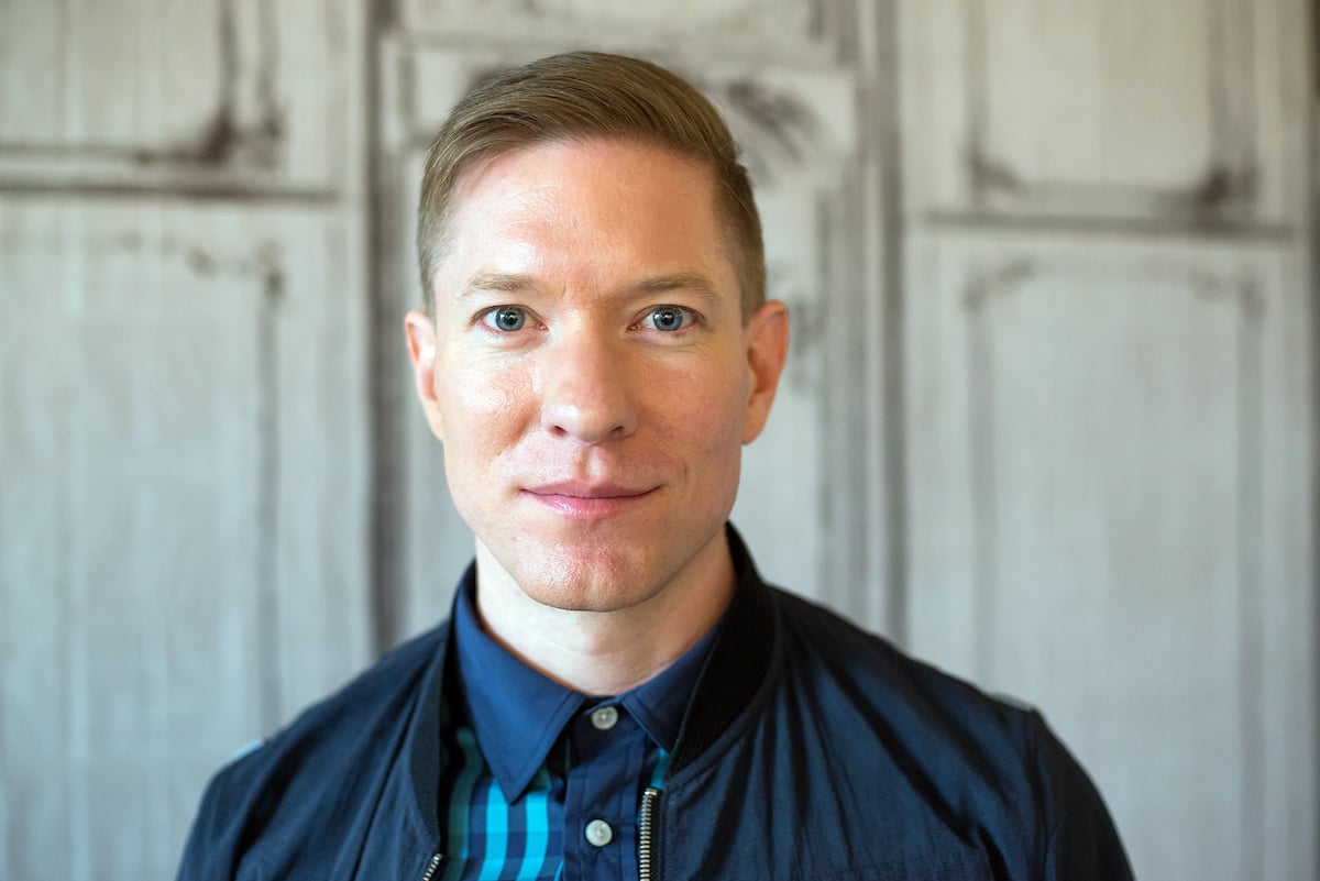 Joseph Sikora wears a blue shirt and jacket
