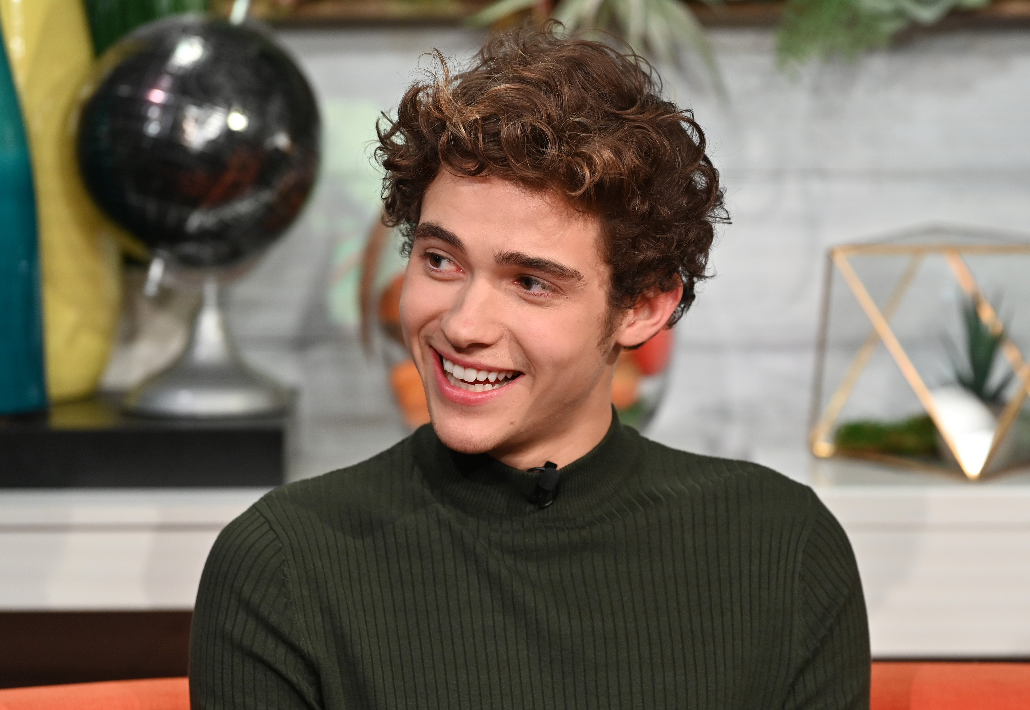 Actor Joshua Bassett visits BuzzFeed's 'AM To DM' to discuss Disney+ web television series 'High School Musical: The Musical: The Series' in green turtleneck