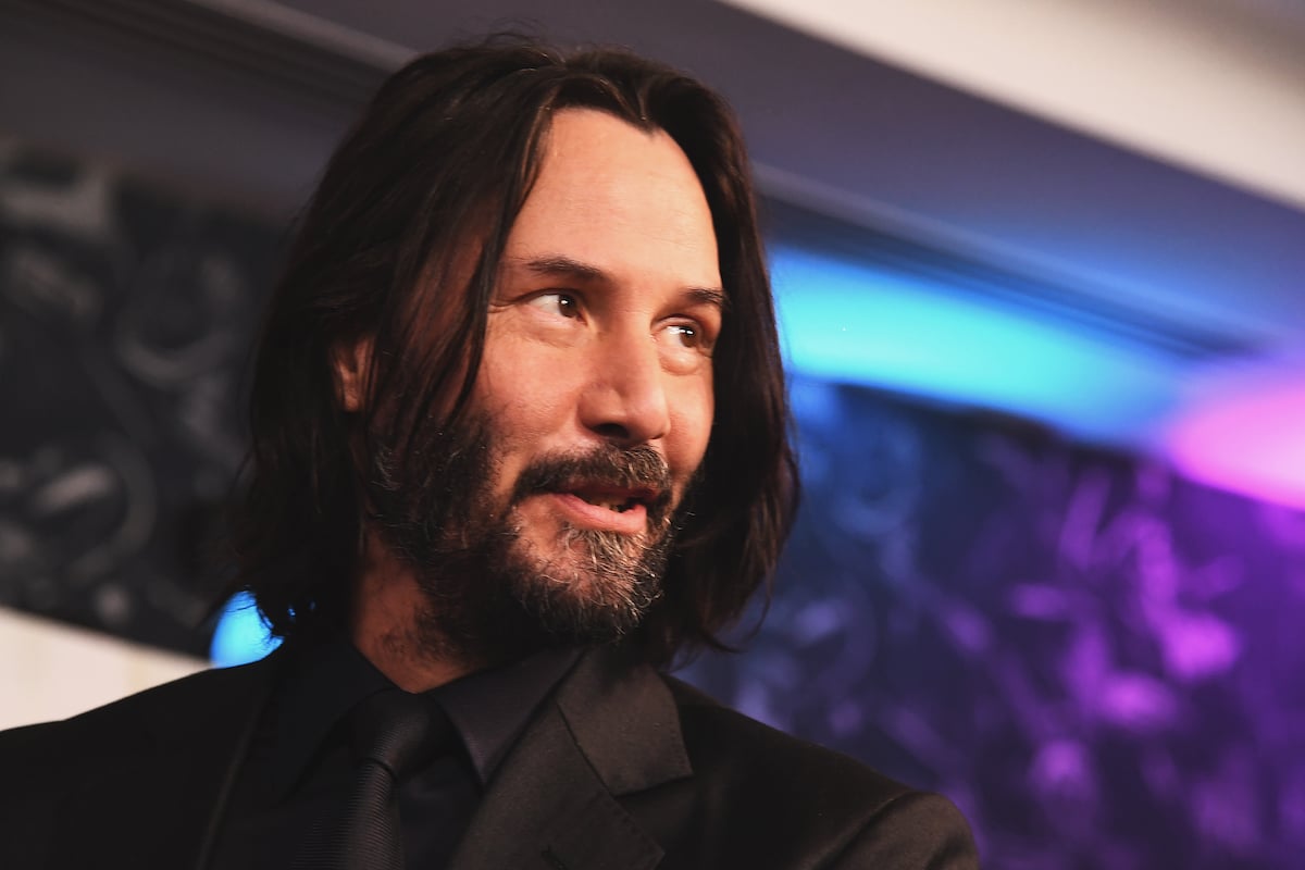 Keanu Reeves wears black and smiles at the 'John Wick' special screenings