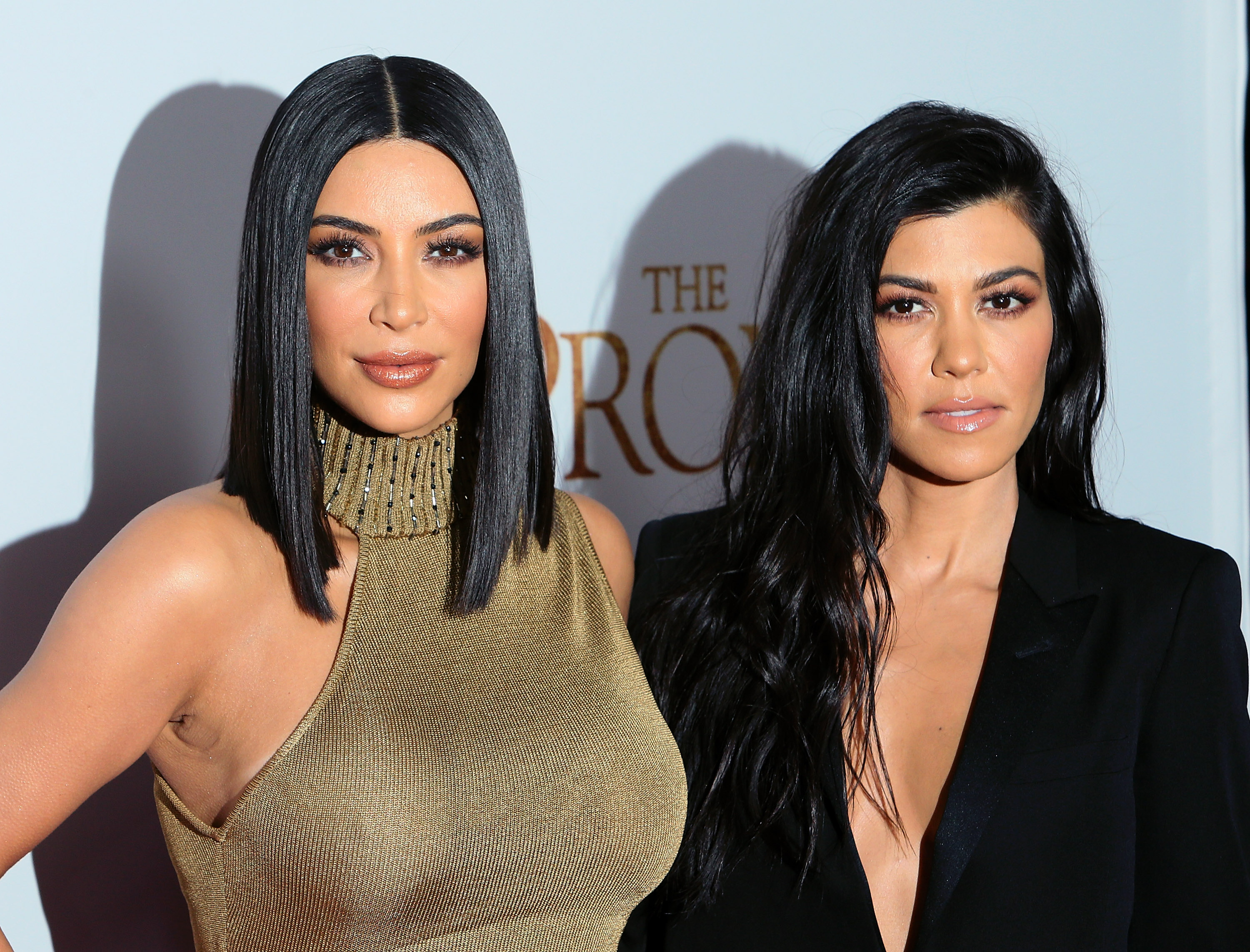 Kim Kardashian West and Kourtney Kardashian pose together on the carpet at the premiere of Open Road Films