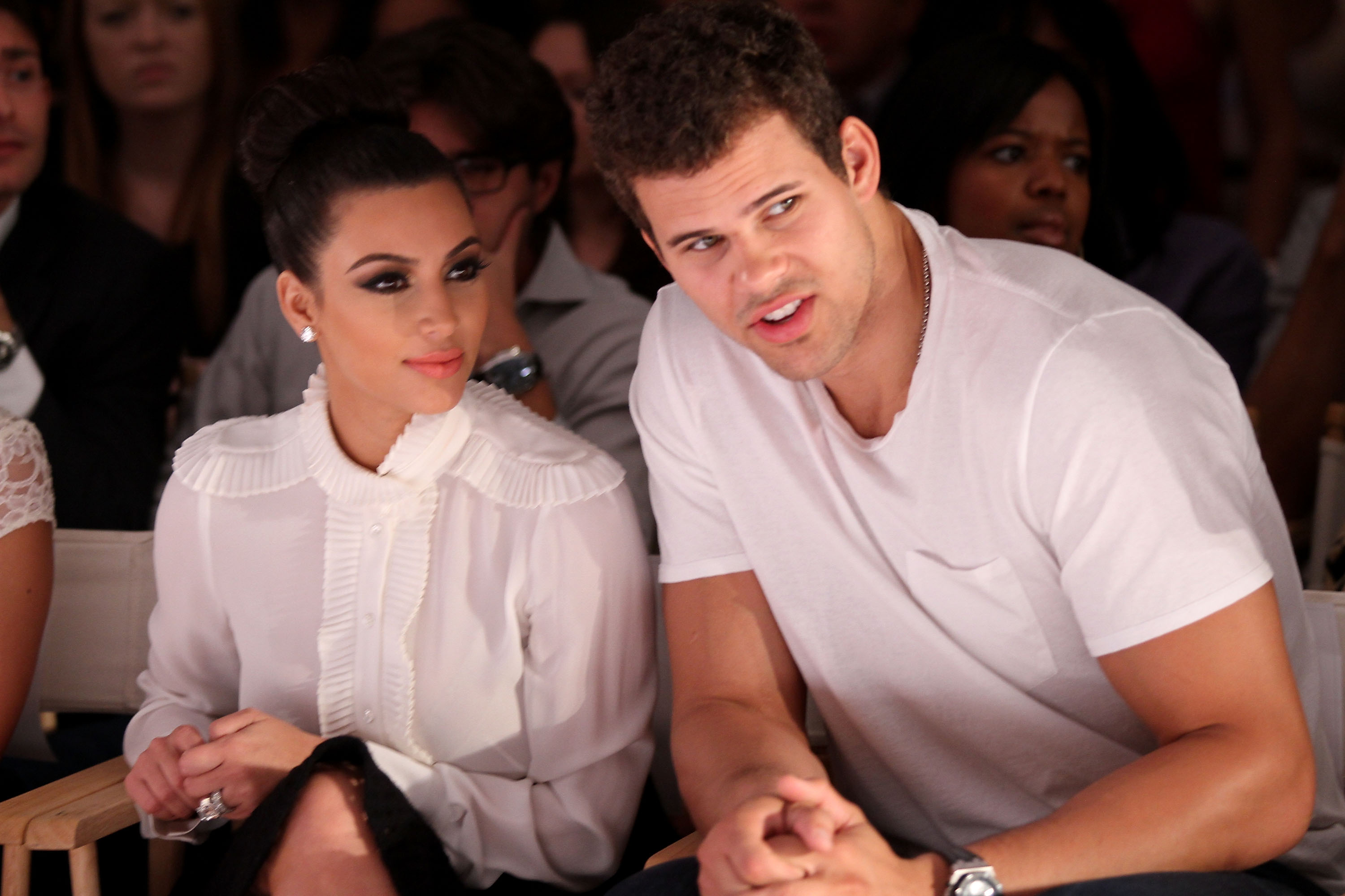 Kim Kardashian West and Kris Humphries posing in white shirts at a Fashion Week event.