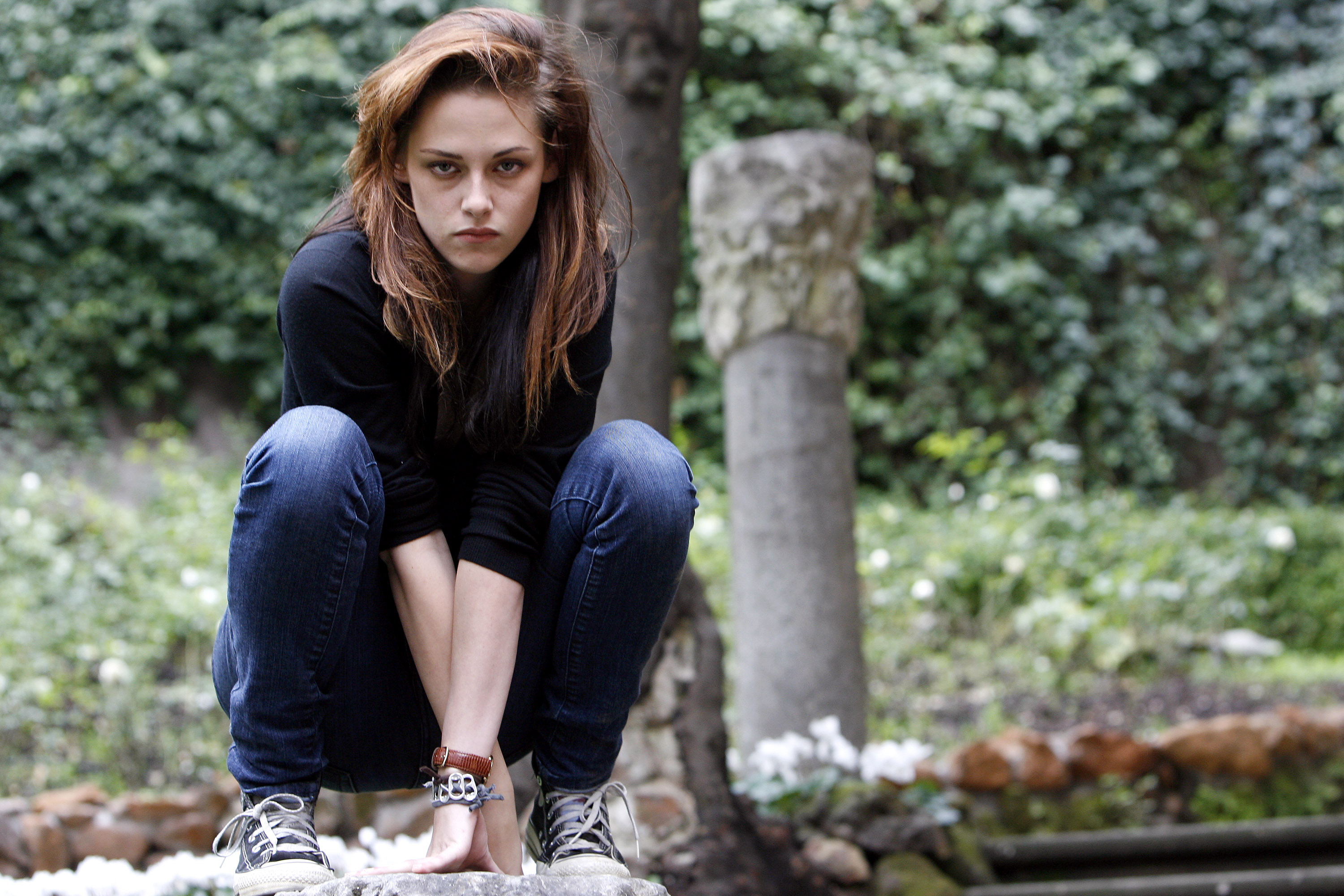 Twilight star Kristen Stewart poses for cast photos while crouching in blue jeans