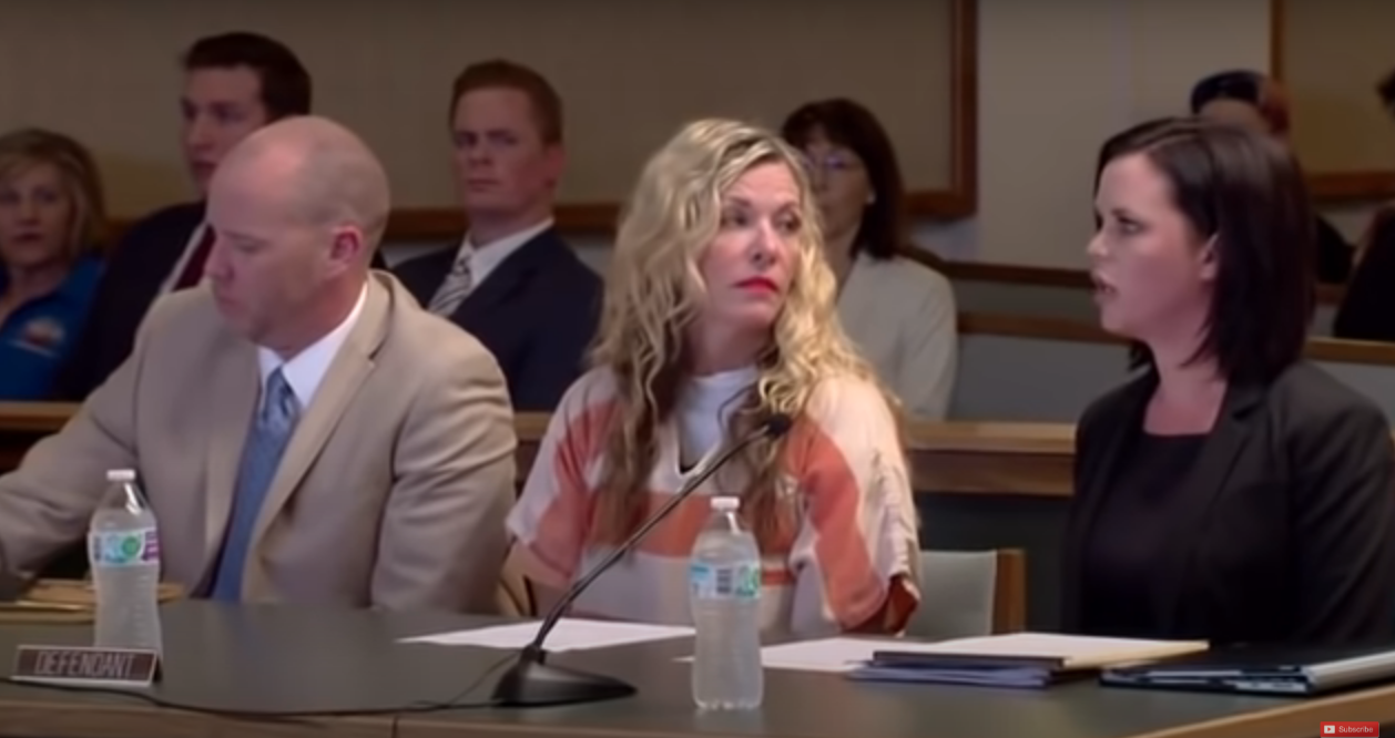 Lori Vallow in orange stripes sits between her attoneys during a court appearance