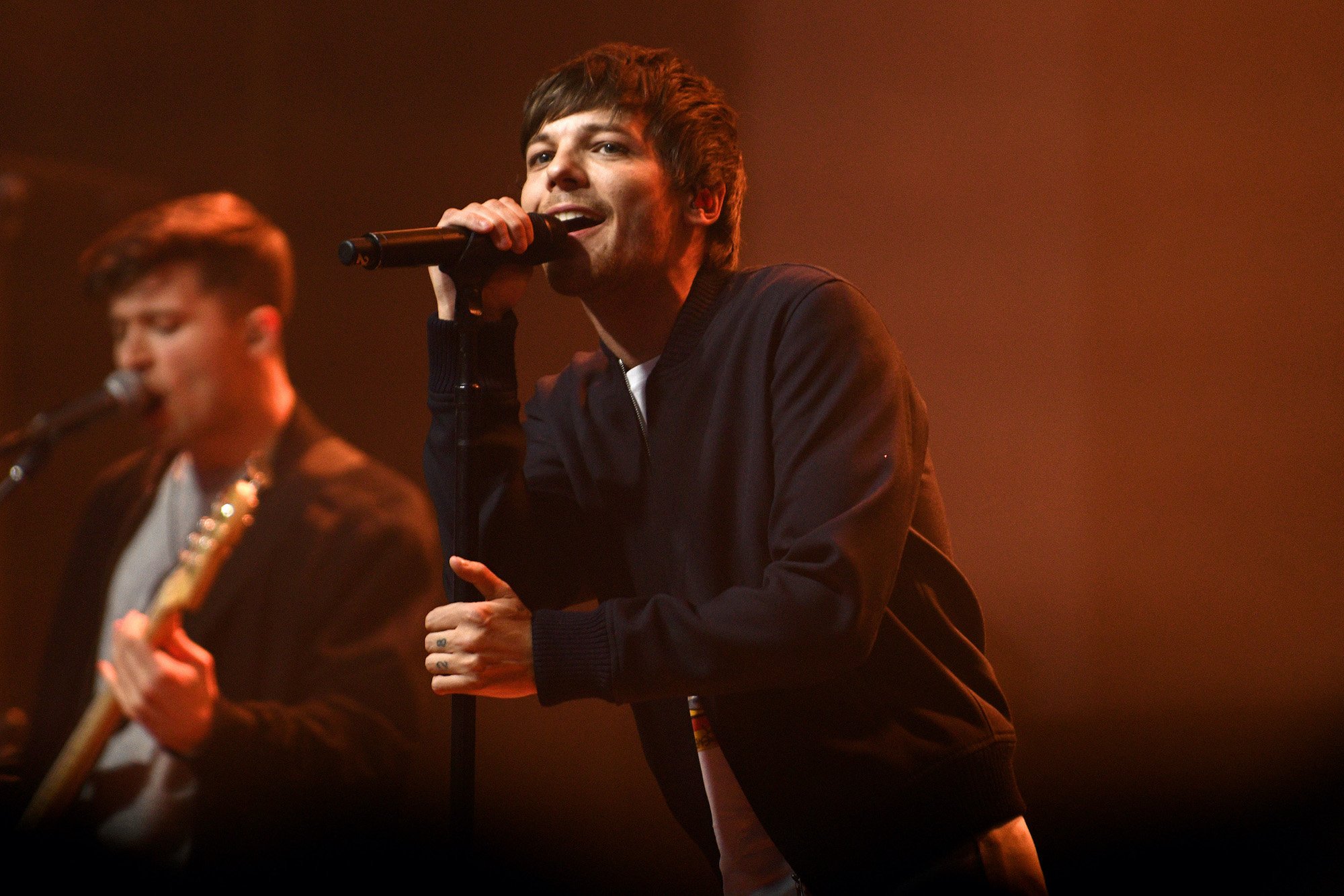 Louis Tomlinson singing into a microphone