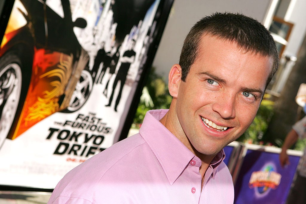 Lucas Black wears a pink shirt with a smile while walking the red carpet at 'The Fast and the Furious: Tokyo Drift premiere.