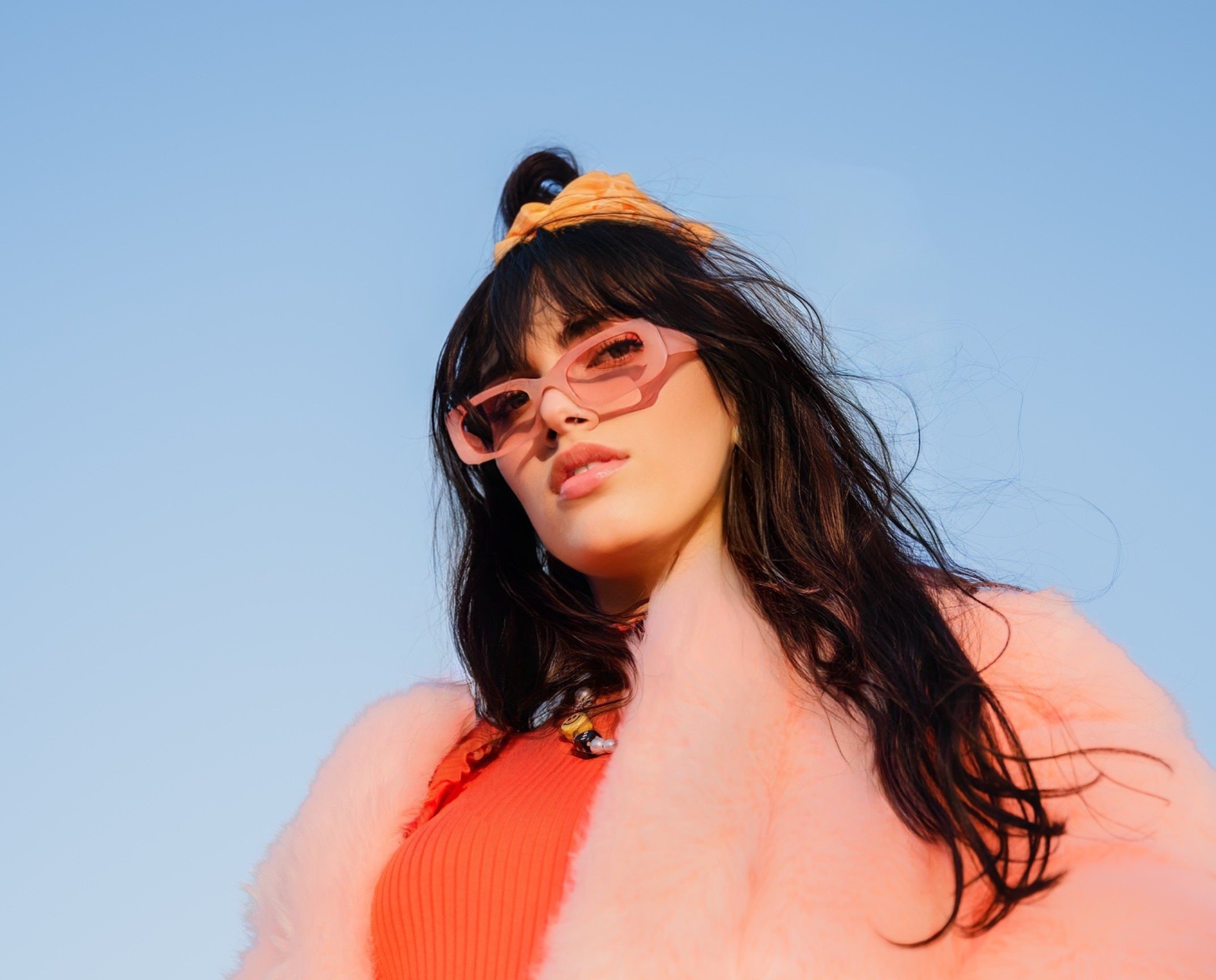 Singer Maggie Andrew in pink sunglasses and a pink fuzzy coat