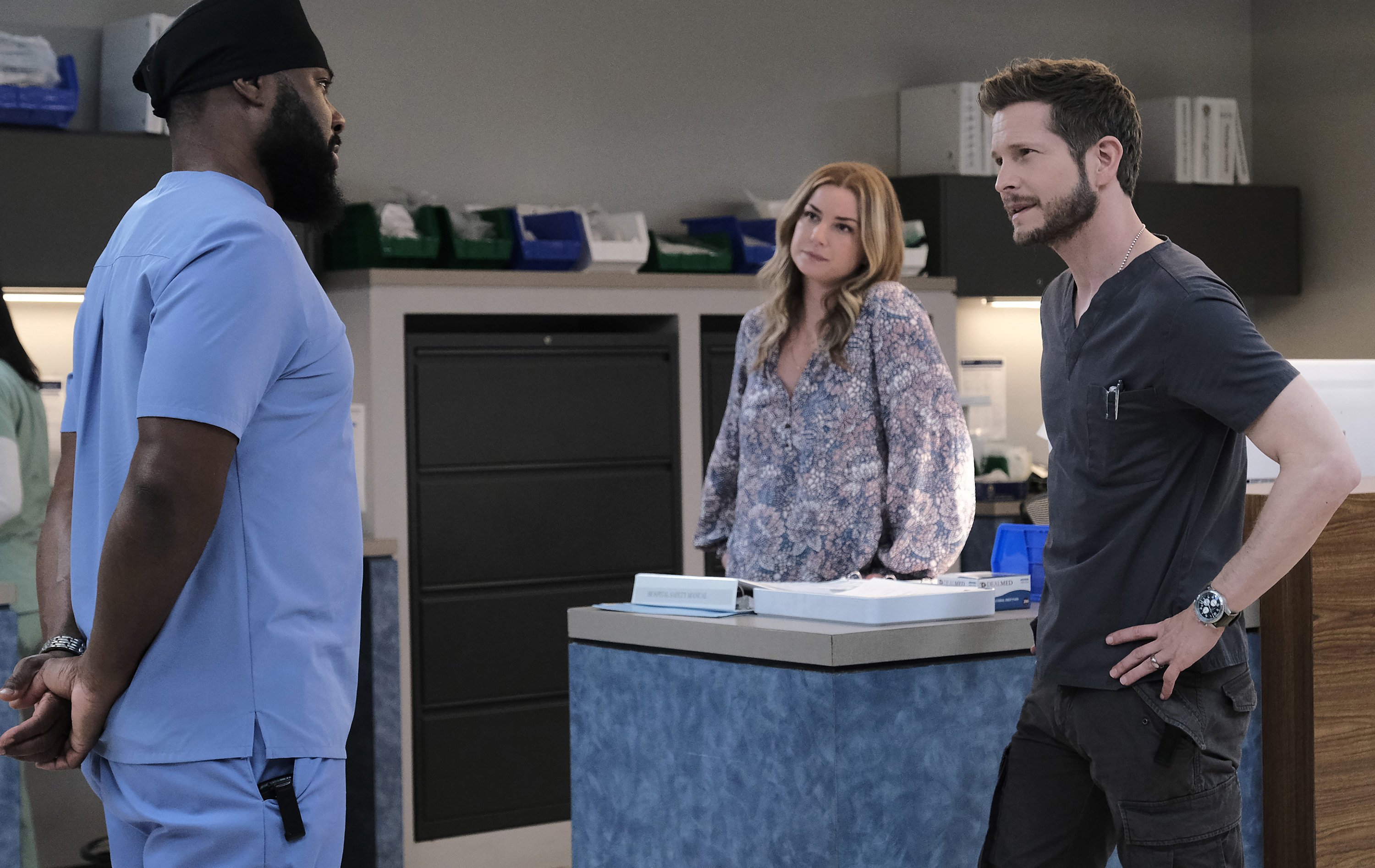 Malcolm-Jamal Warner, Emily VanCamp and Matt Czuchry standing beside a desk at Chastain Hospital on 'The Resident'