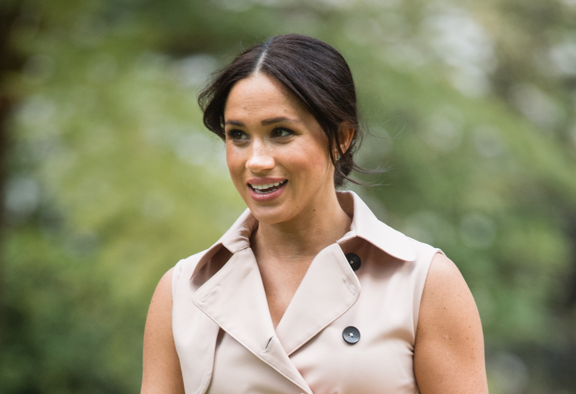 Duchess of Sussex looking on in a beige dress