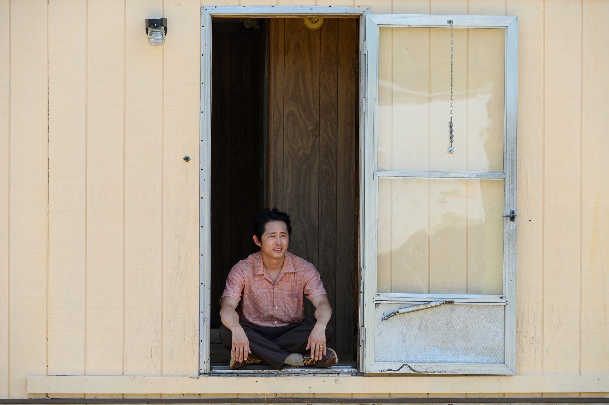 Minari: Steven Yeun sits in his doorway