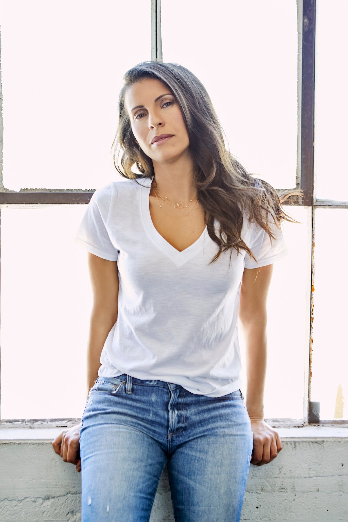 Natalia Castellanos wearing a white t-shirt in front of a window