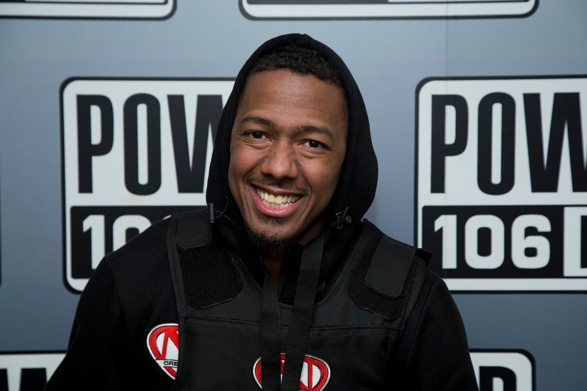 Nick Cannon sitting down and smiling to announce radio syndication in Burbank, California