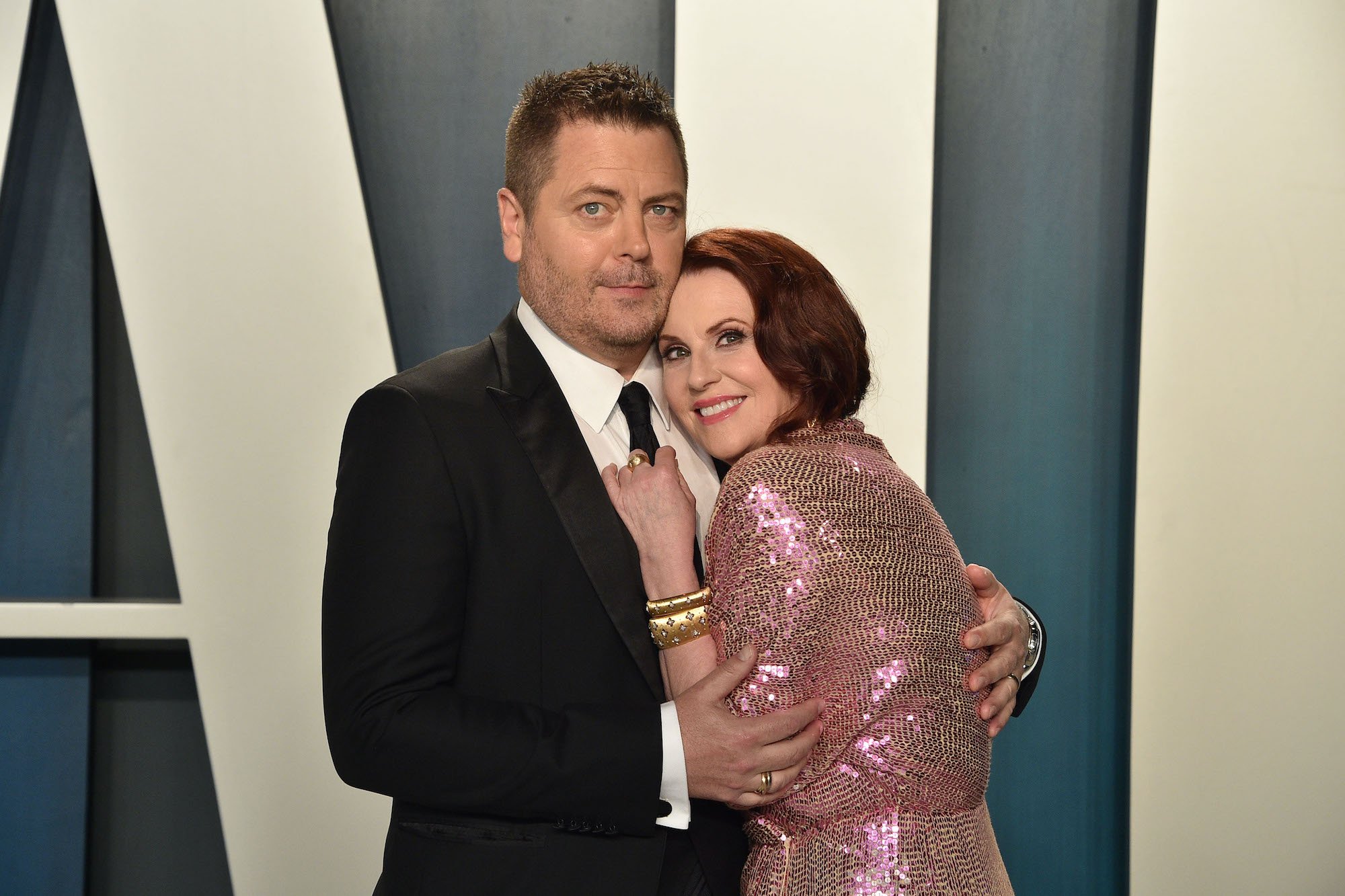 Nick Offerman and Megan Mullany embracing, smiling, on a red carpet