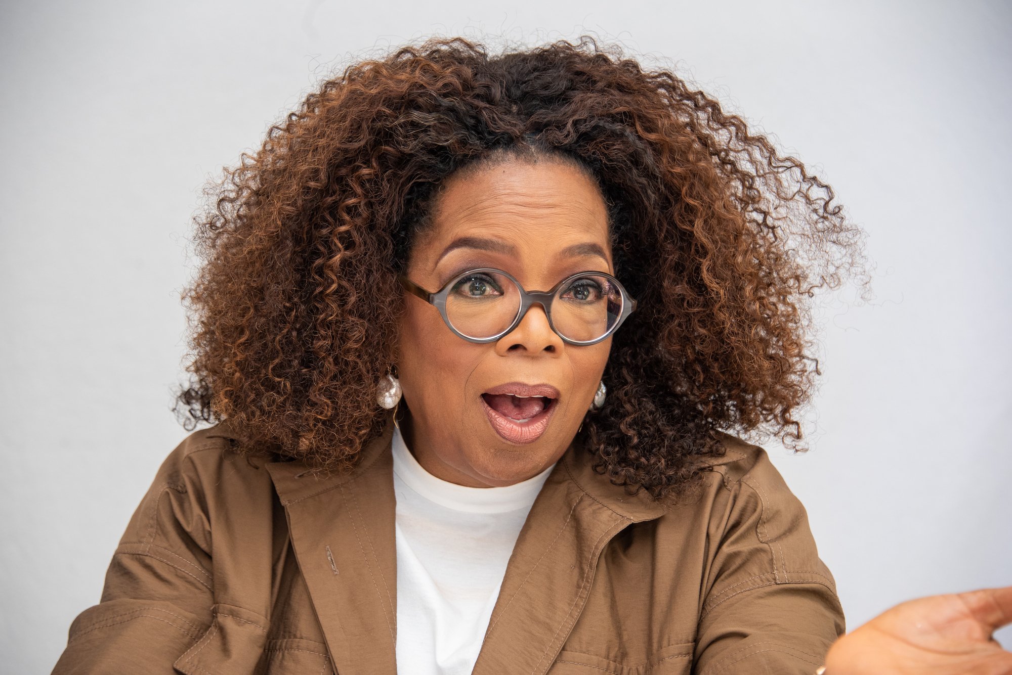 Oprah Winfrey speaking in front of a white wall