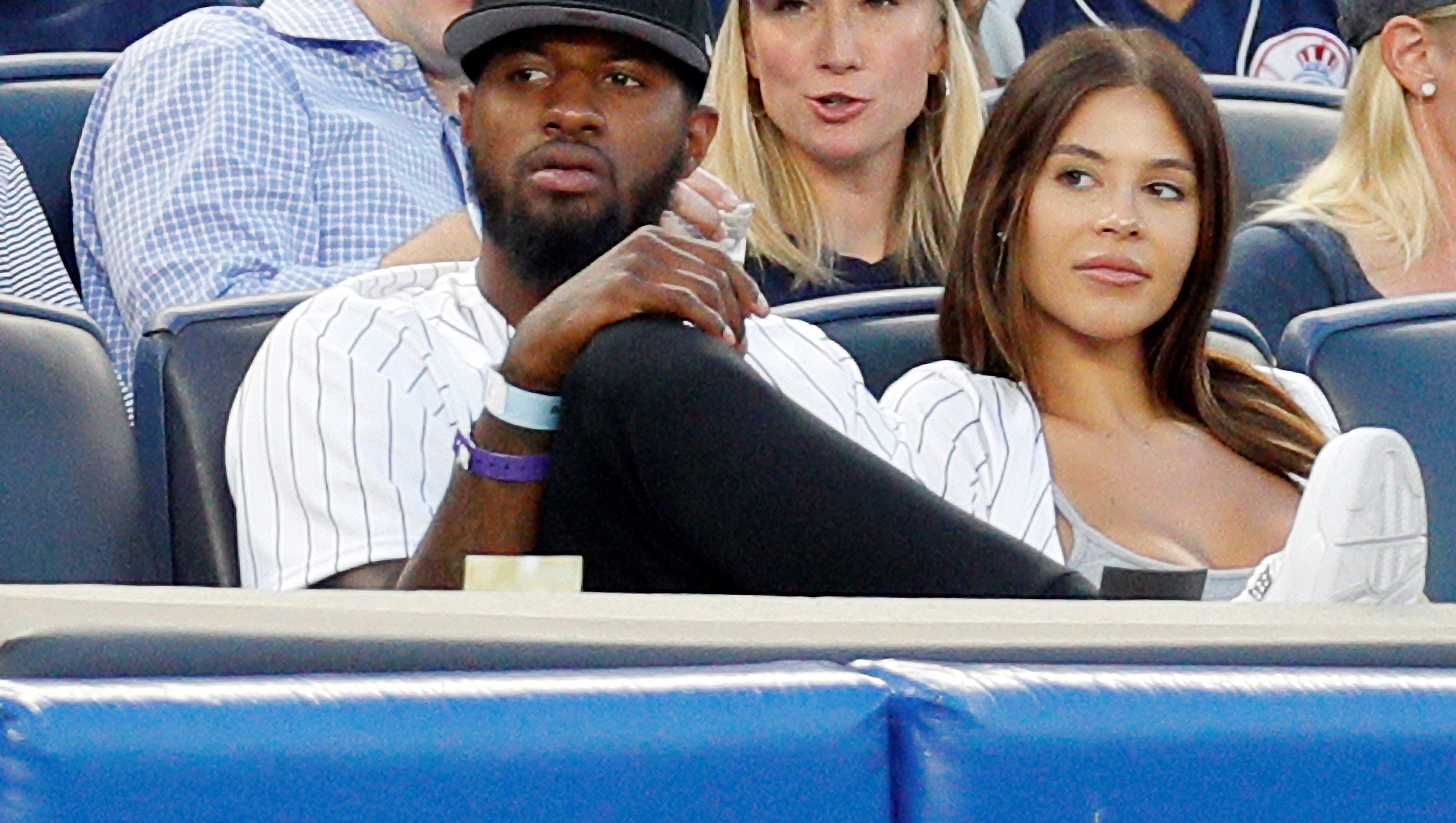 Paul George and Daniela Rajic sitting in the stands watching a baseball game between the Detroit Tigers and the New York Yankees