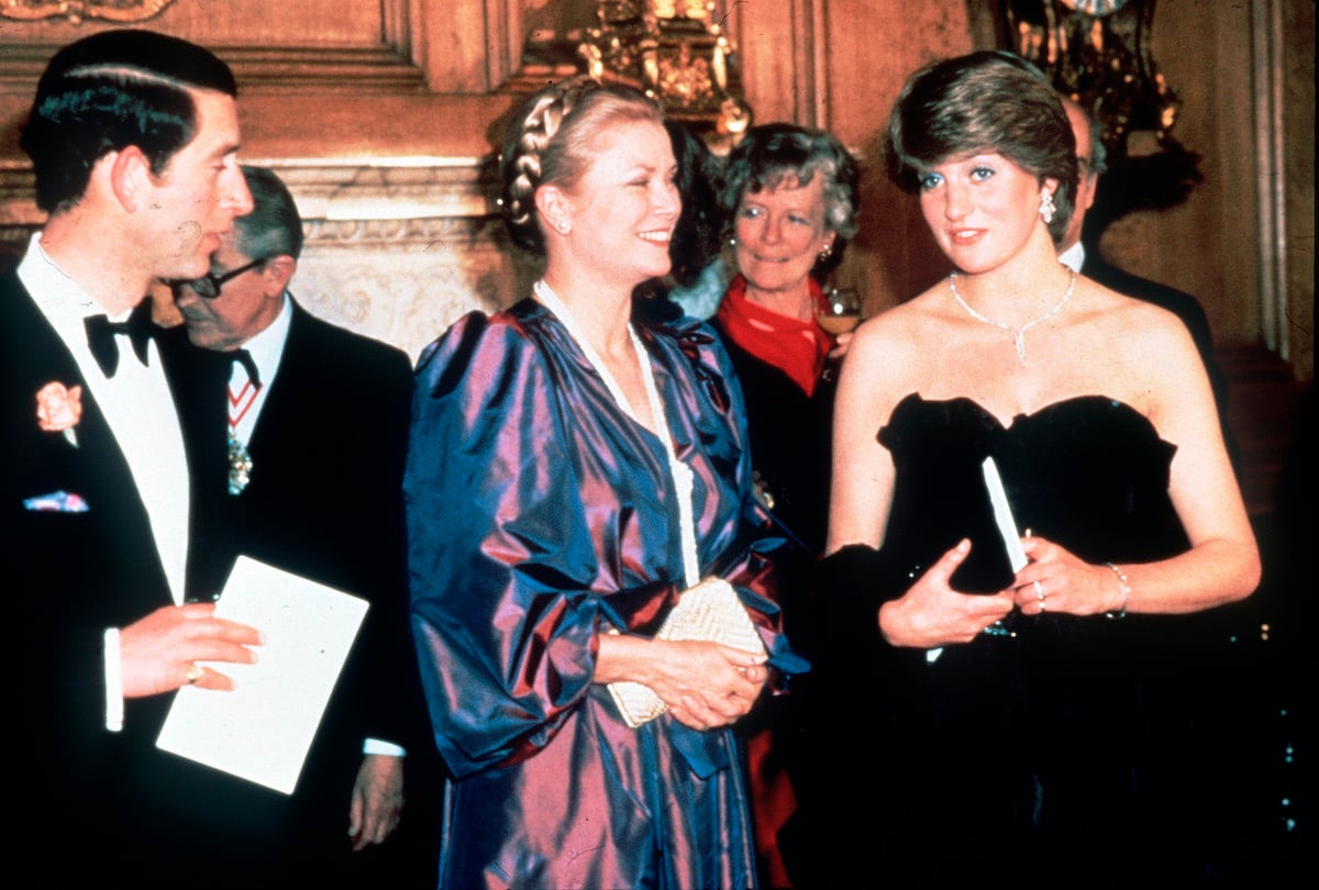 Prince Charles and Princess Diana stand on either side of Grace Kelly