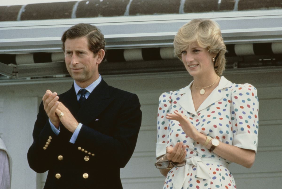 Prince Charles in a suit and Diana, Princess of Wales in a white dress with colored dotsclapping
