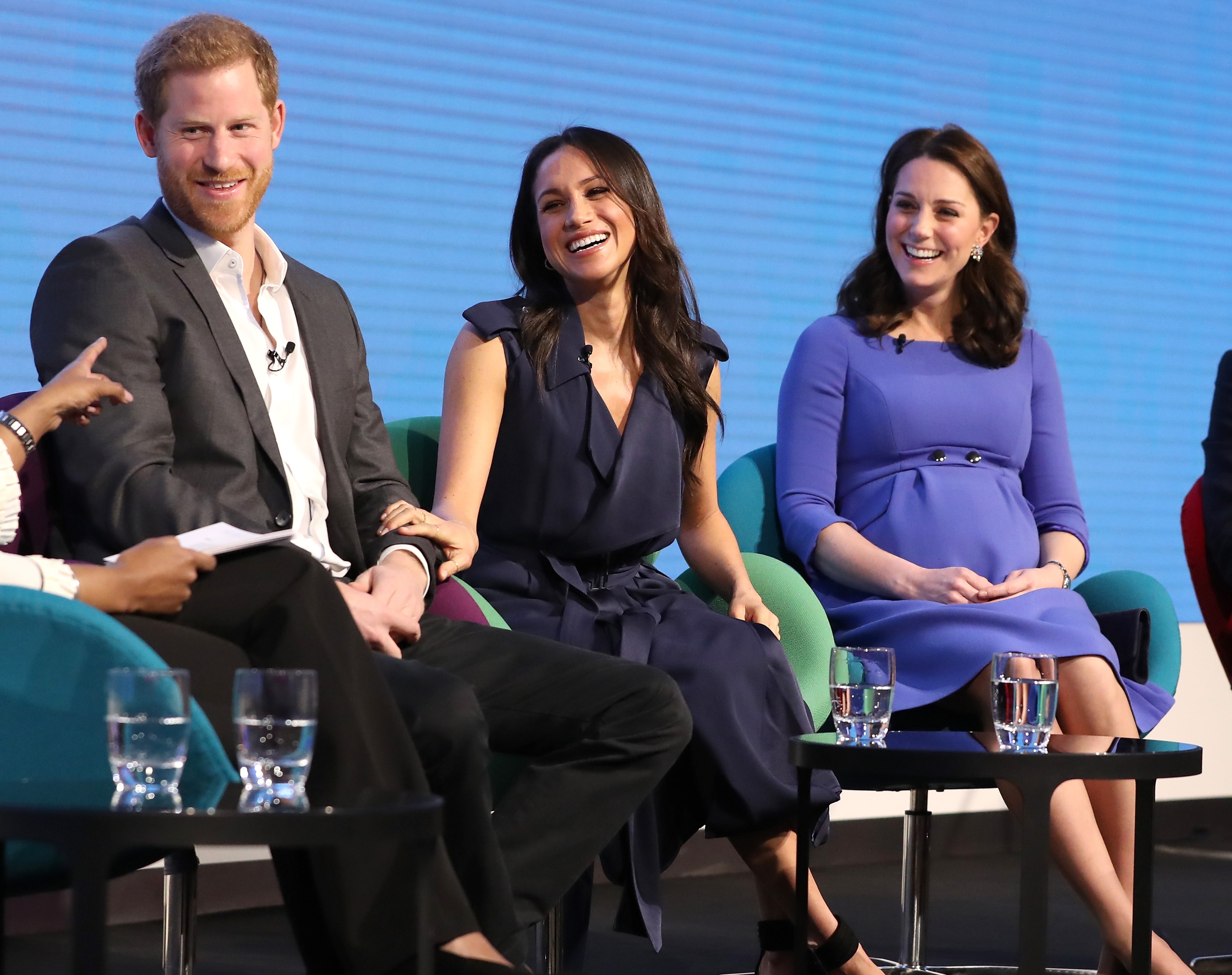Prince Harry, Meghan Markle, and Kate Middleton sitting onstage together at the Royal Foundation Forum