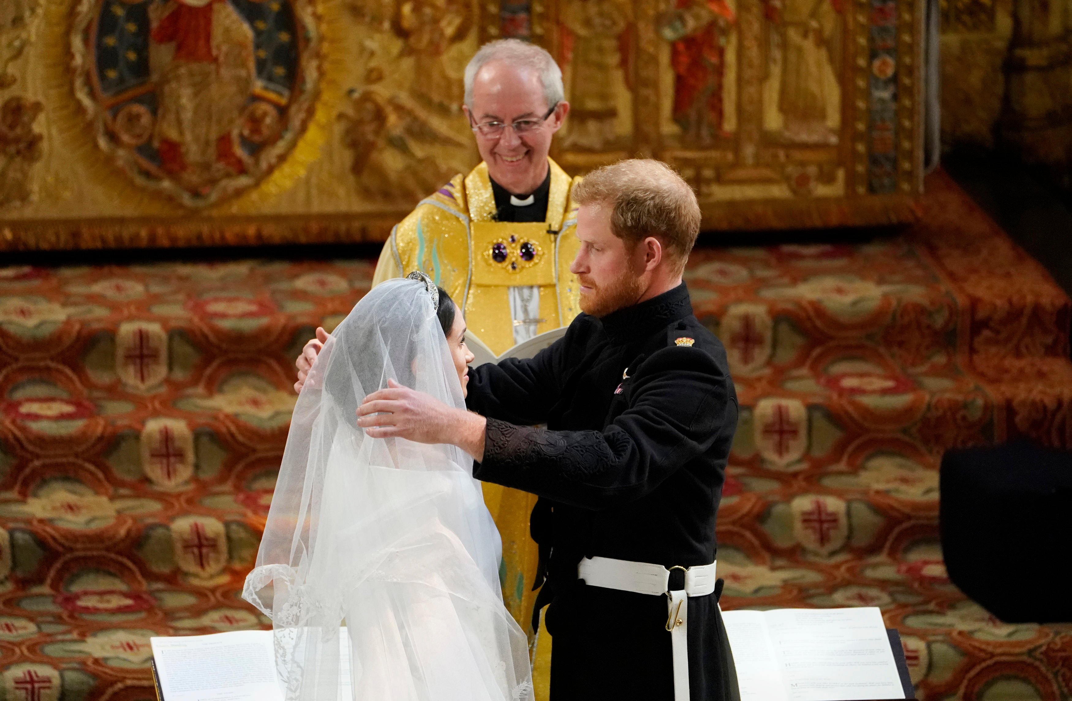 Prince Harry removes the veil of Meghan Markle at the altar before Archbishop of Canterbury Justin Welby