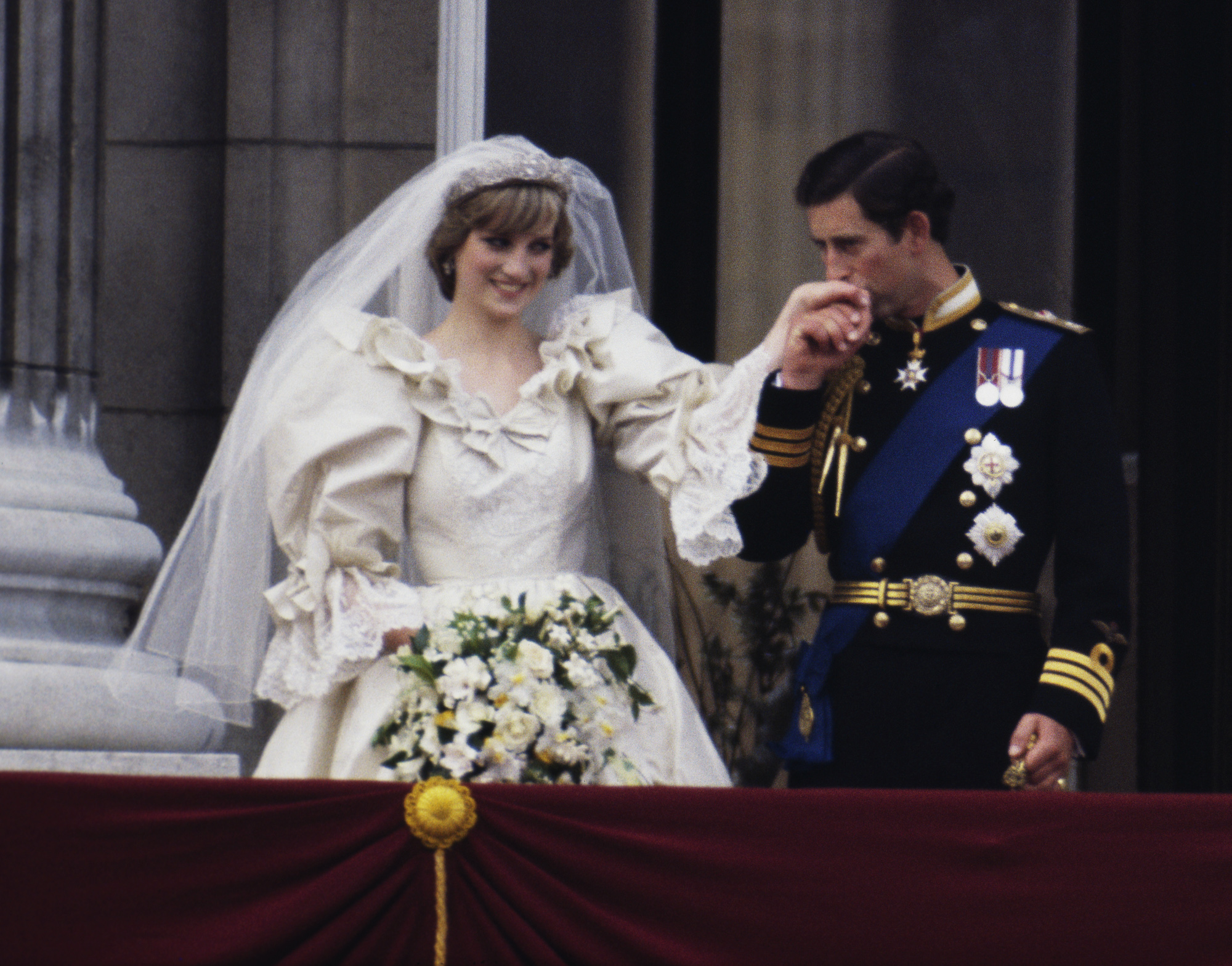 After Princes Diana’s wedding ceremony, Prince Charles gently kisses Diana’s hand as they greet the crowd from their balcony.