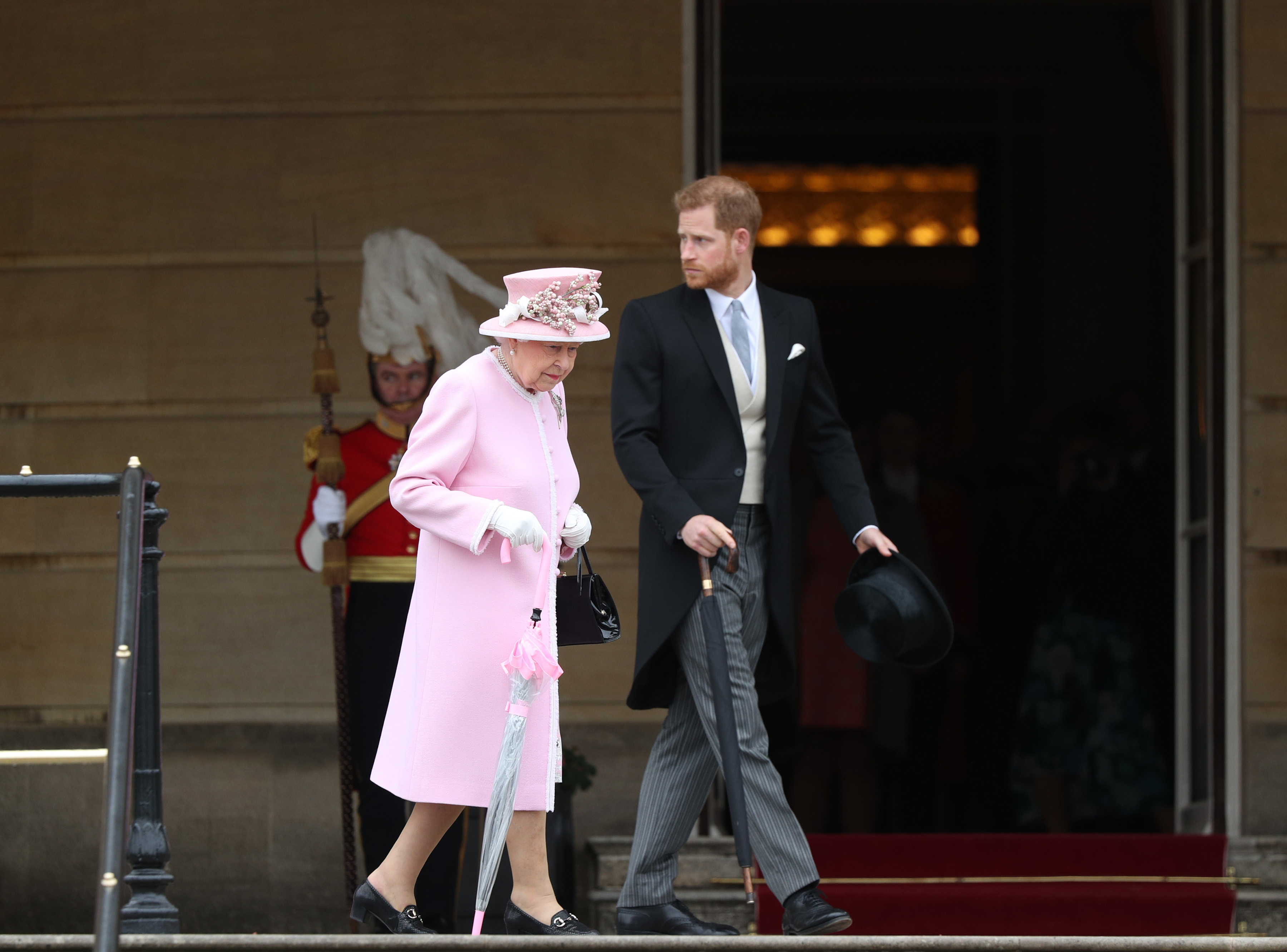 Queen Elizabeth II and Prince Harry walking together toward the Royal Garden Party at Buckingham Palace in 2019