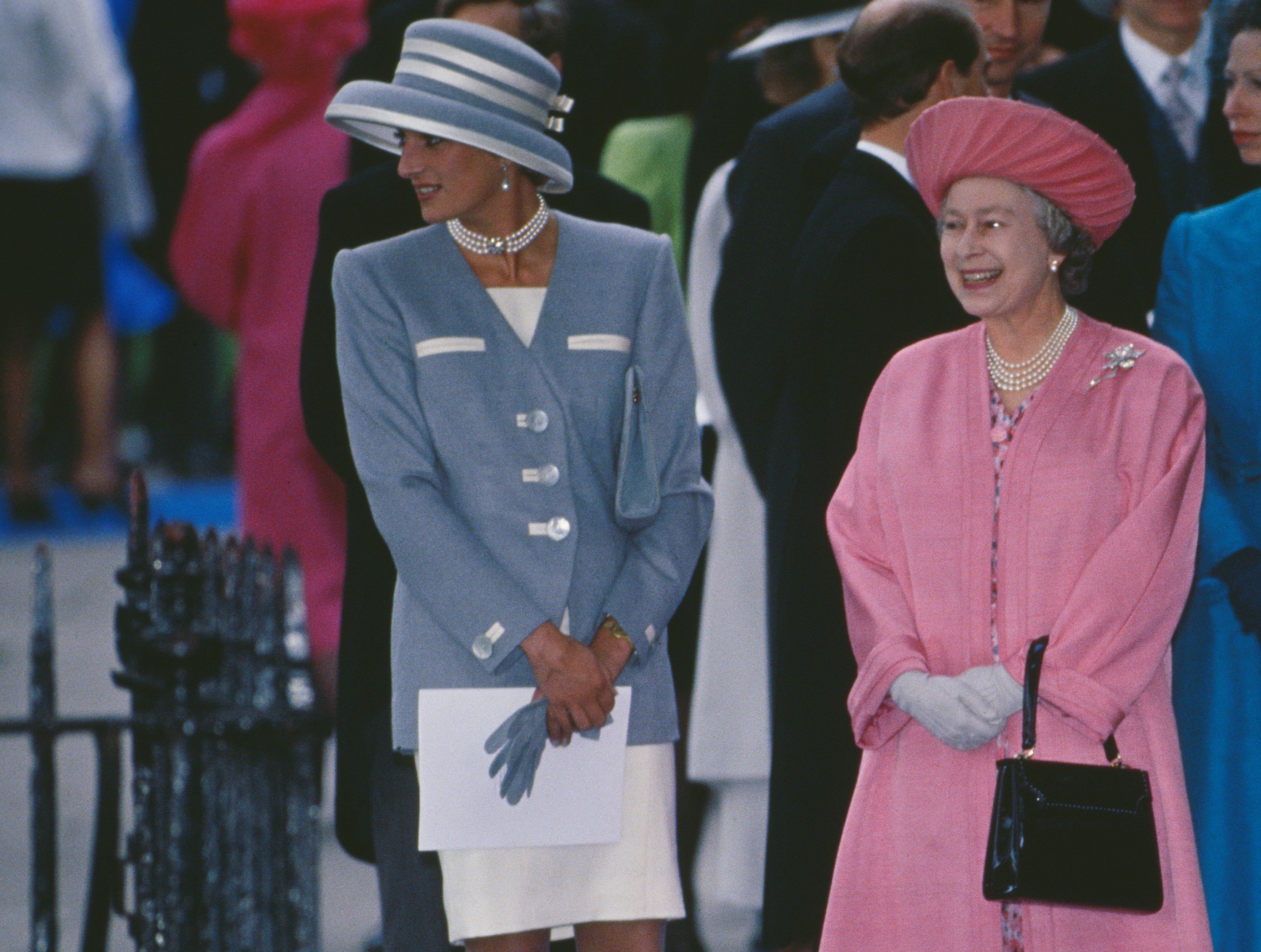 Queen Elizabeth II and Princess Diana standing next to each other at the wedding of Viscount Linley and Serena Stanhope