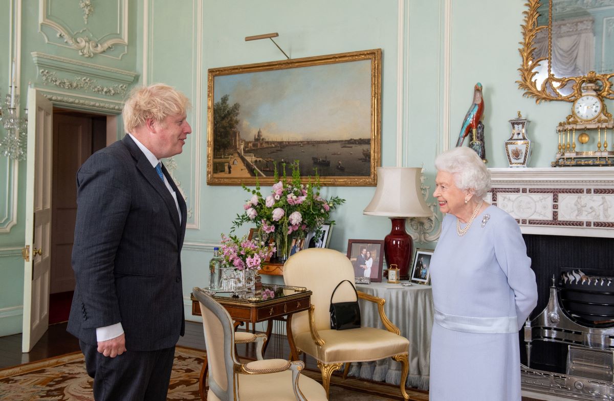 Queen Elizabeth II in a light blue dress and Boris Johnson in a dark suit