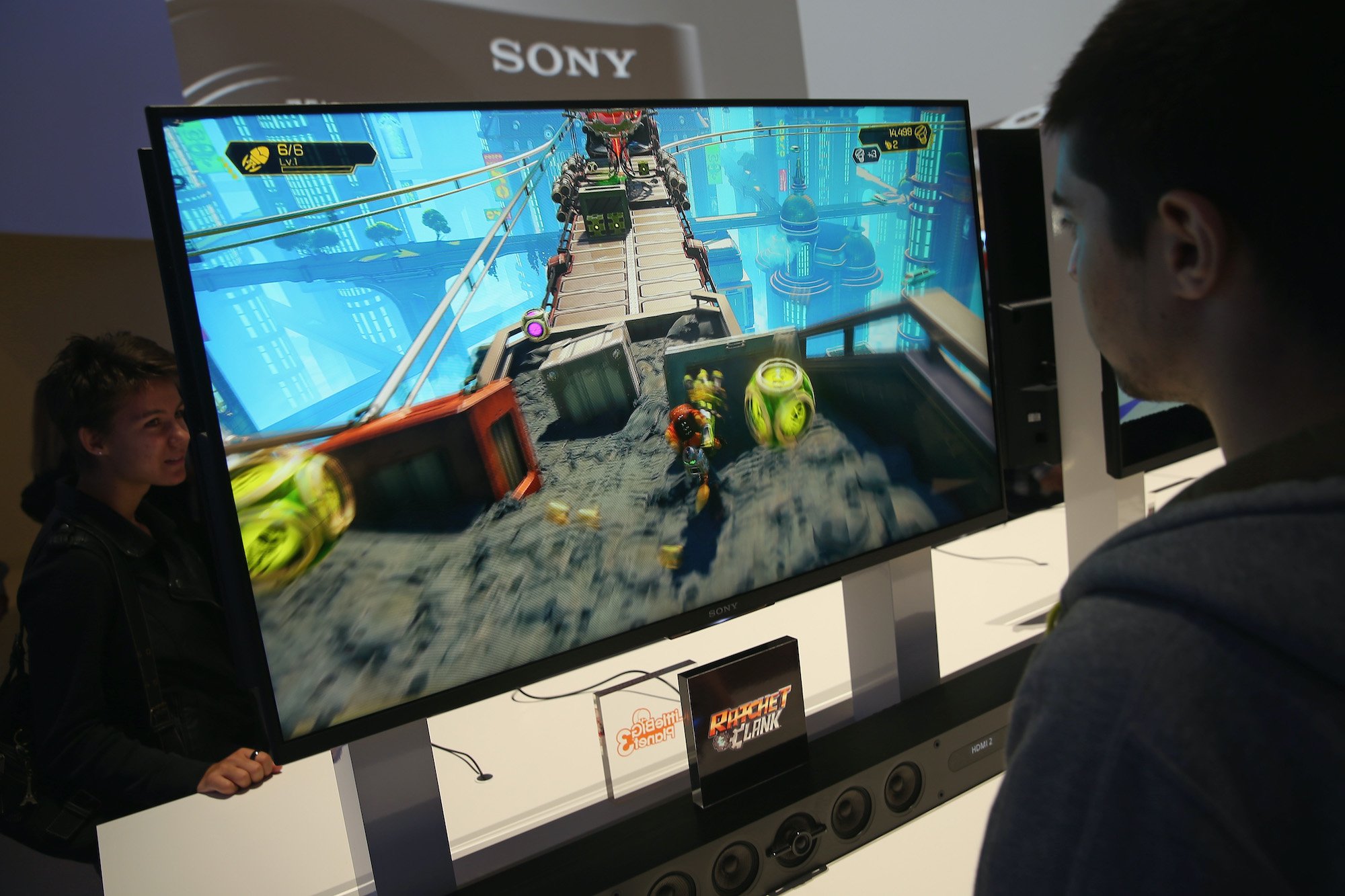 A fan plays the video game 'Ratchet and Clank' on a large computer monitor