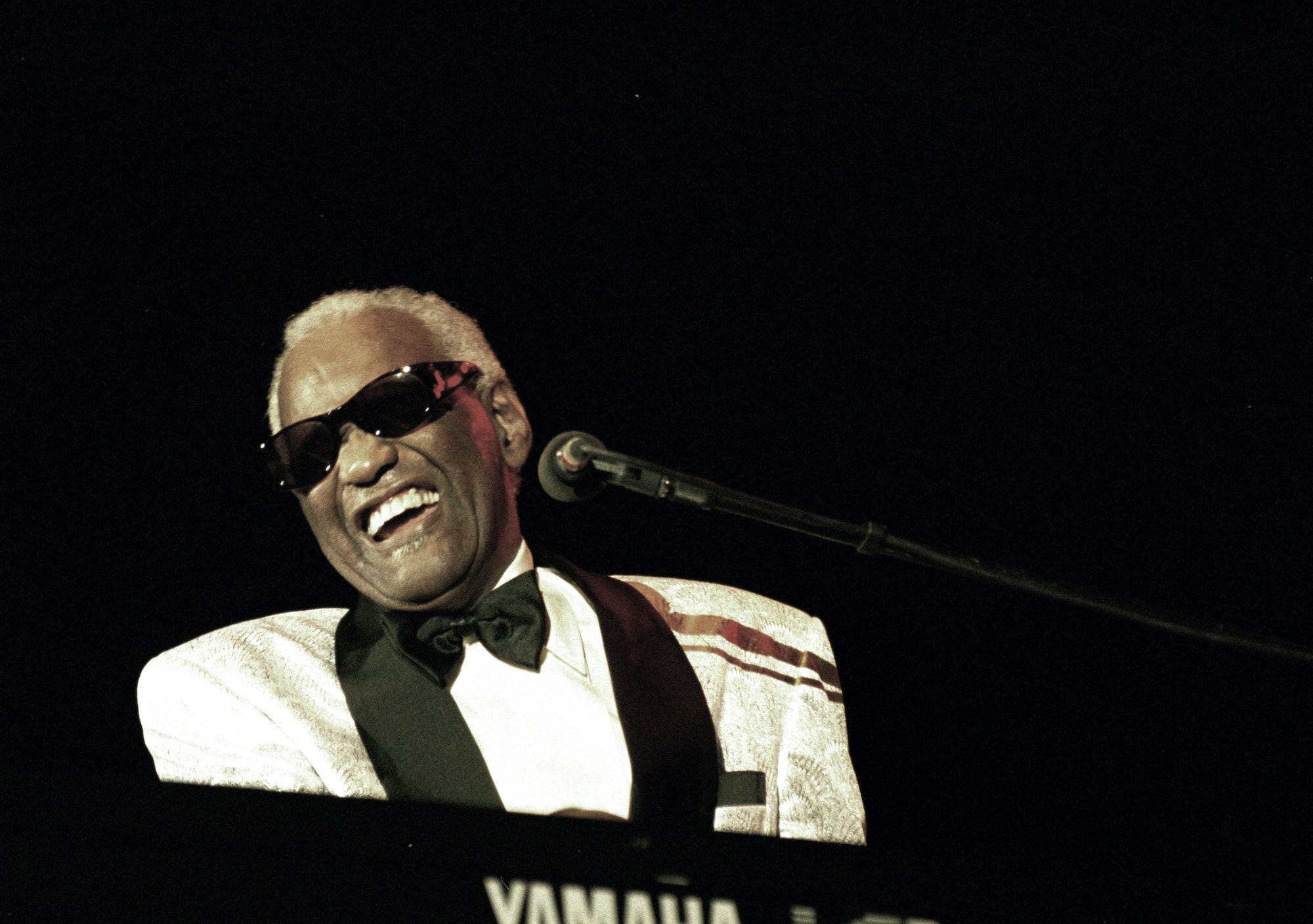 Ray Charles smiling, playing the piano