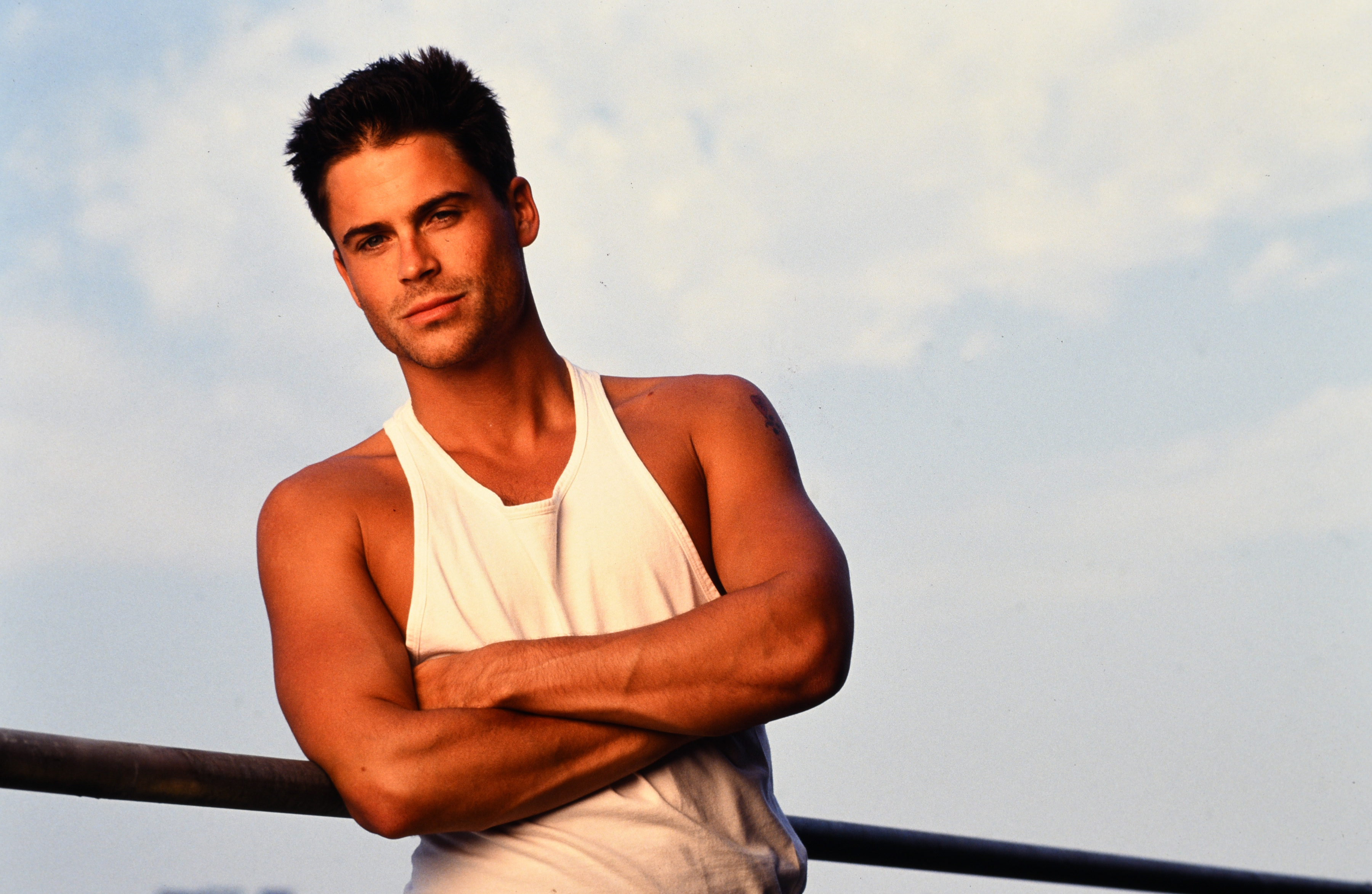 Rob Lowe photographed in front of a cloud-filled blue sky in 1990, the year he decided to get sober.