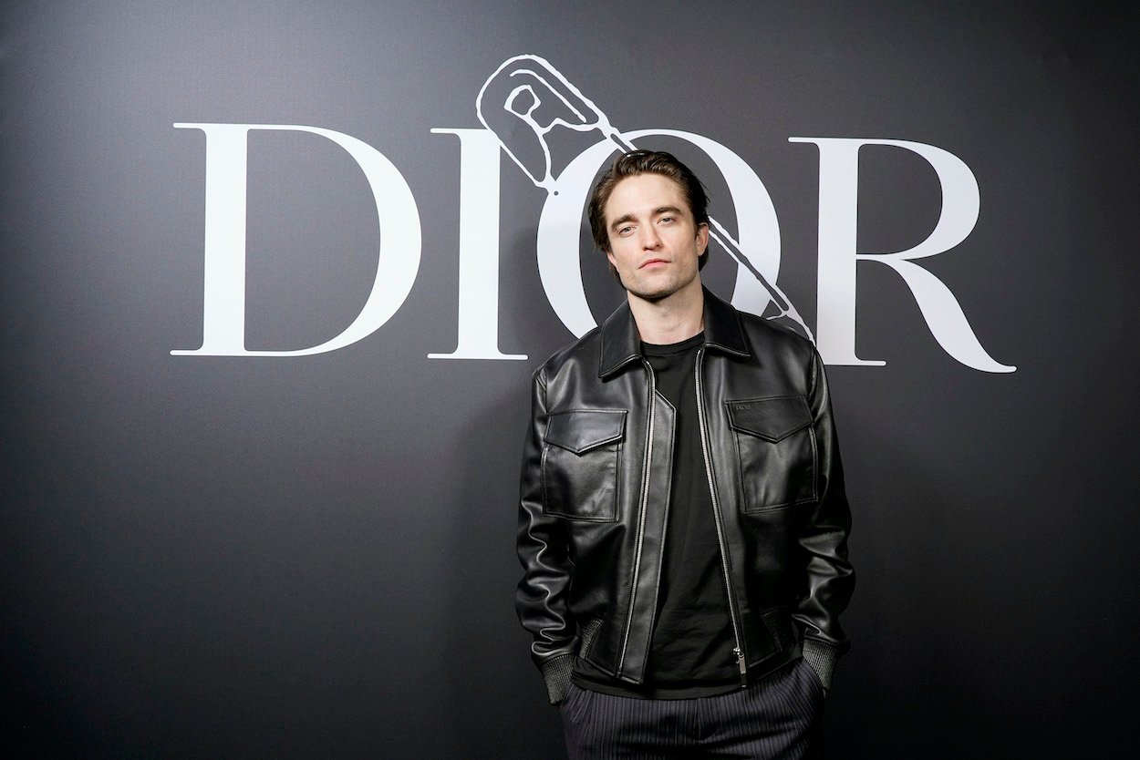 Robert Pattinson poses in a leather jacket at Paris Fashion Week