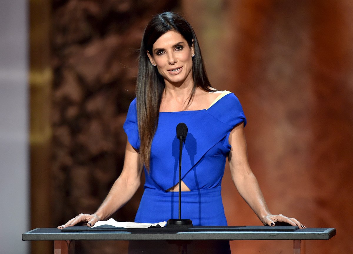 Sandra Bullock wears a blue outfit and speaks onstage at the AFI Life Achievement Award: A Tribute to Jane Fonda
