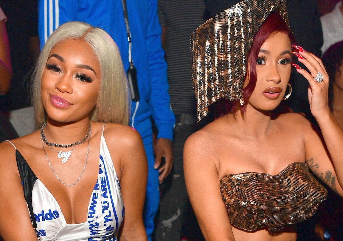 Saweetie and Cardi B posing for a photo while seated at an event