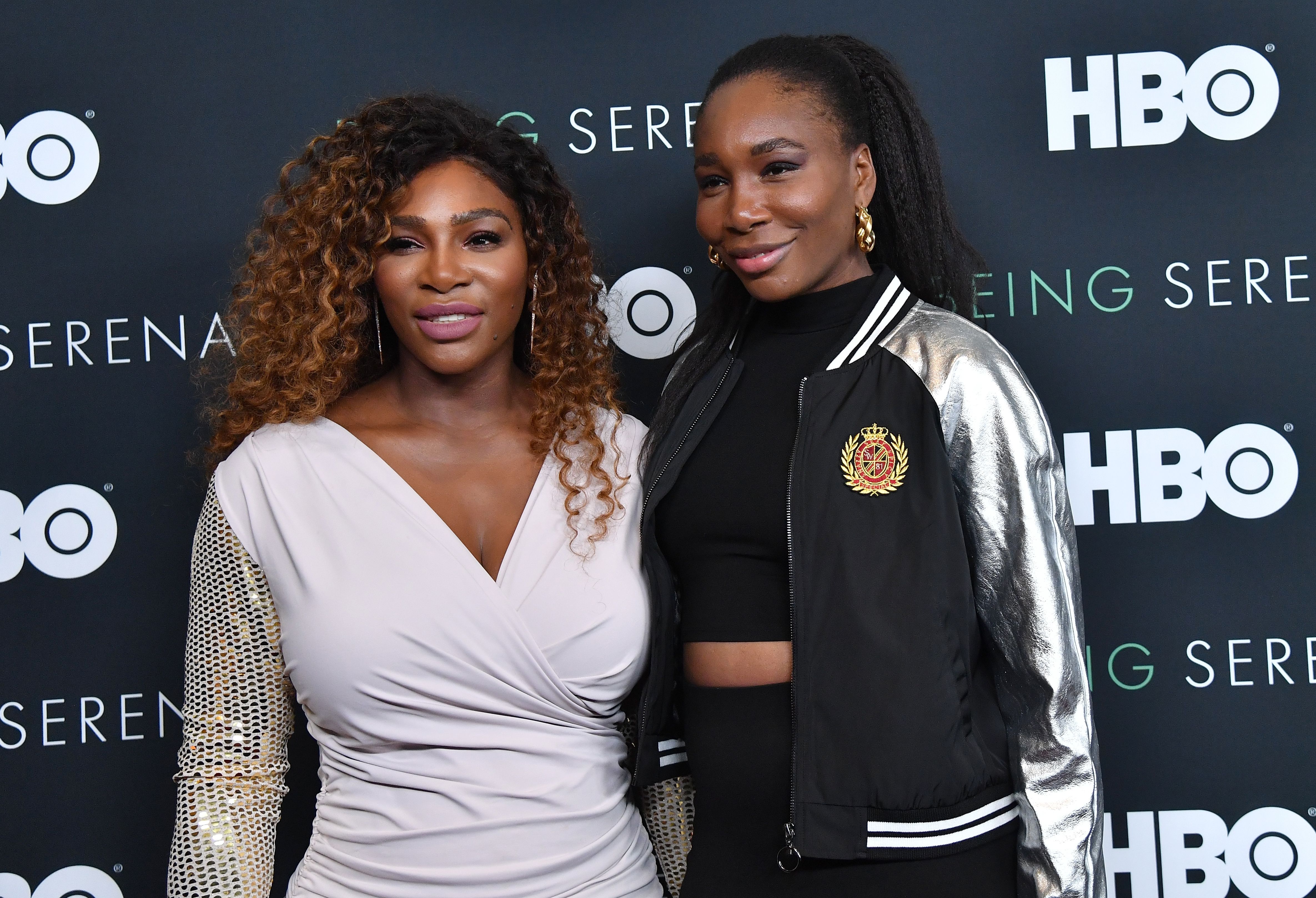 Serena Williams and Venus Williams smile and pose together on red carpet at HBO premiere of 'Being Serena'