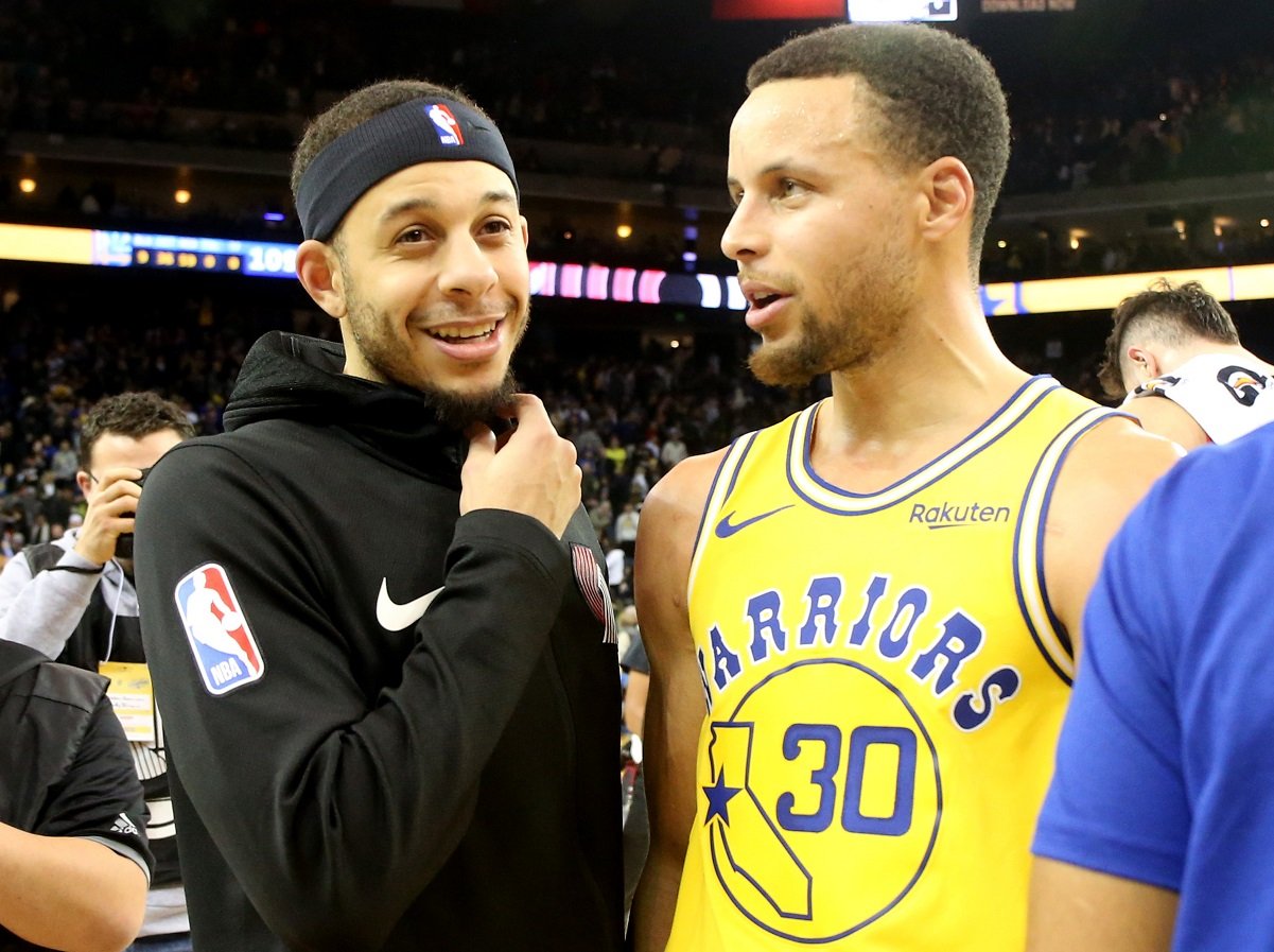 Seth Curry talks with his brother Stephen Curry after game at the Oracle Arena
