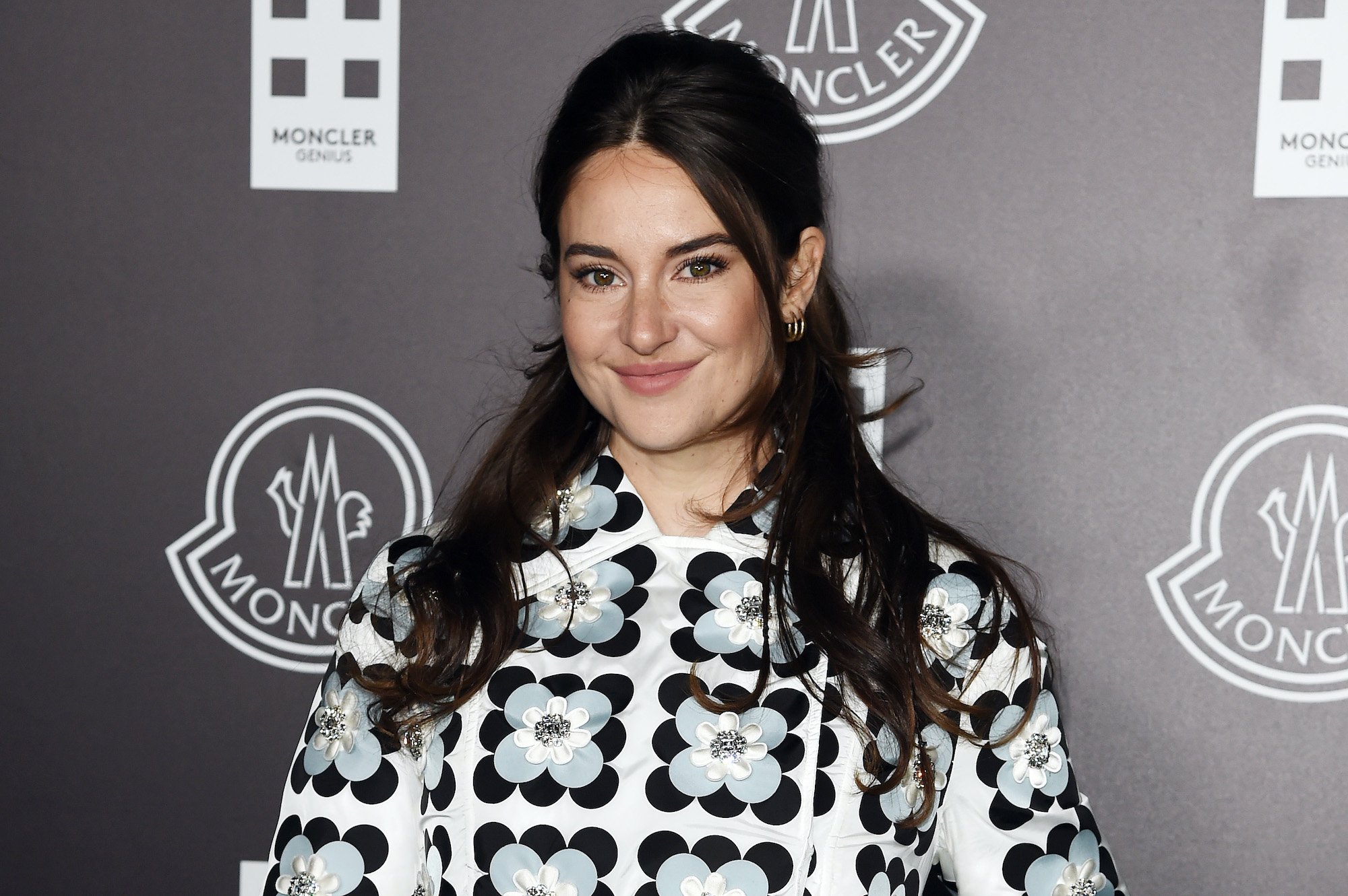 Shailene Woodley smiling in front of a gray background