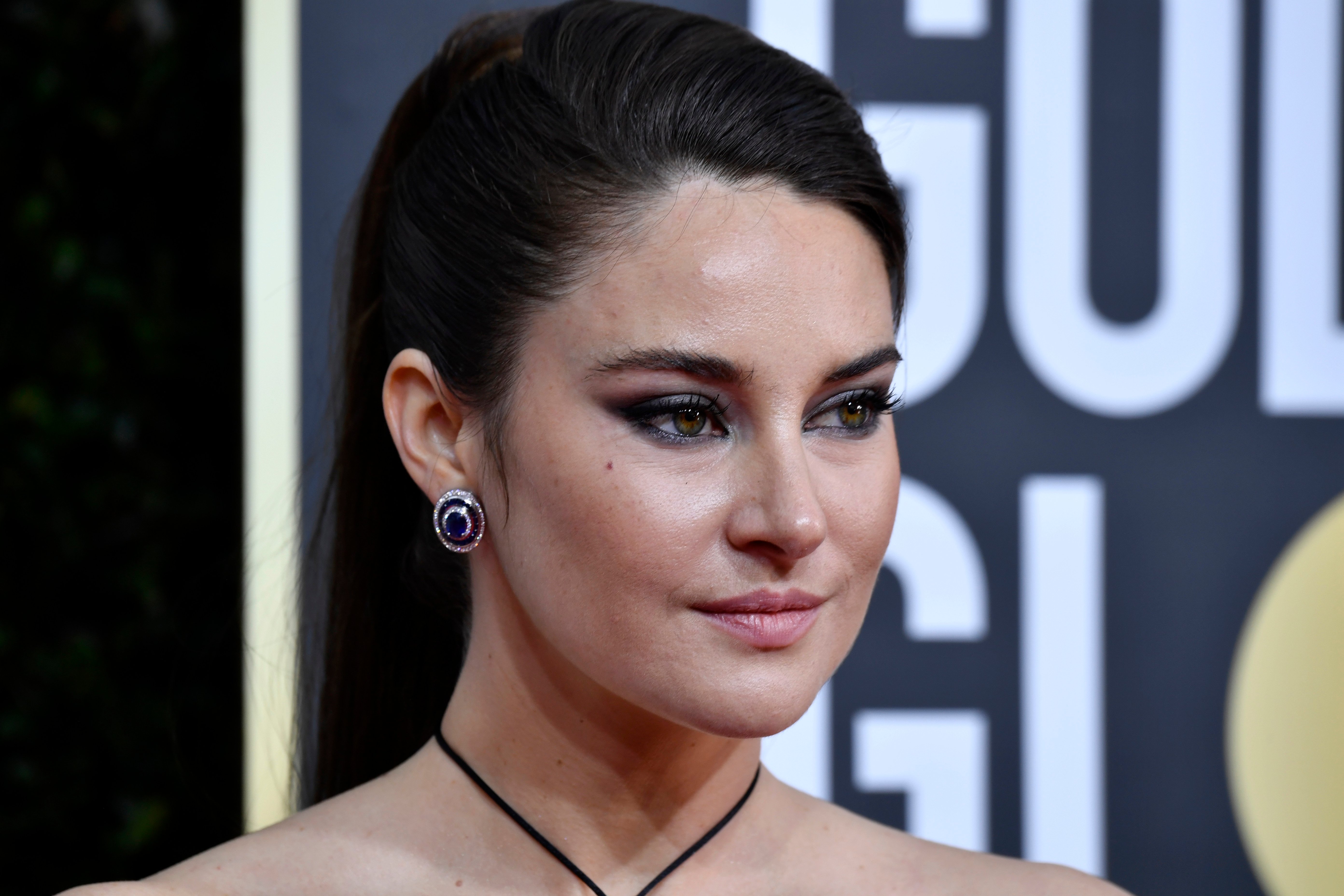 movie star Shailene Woodley with a sleek hairdo and purple earrings