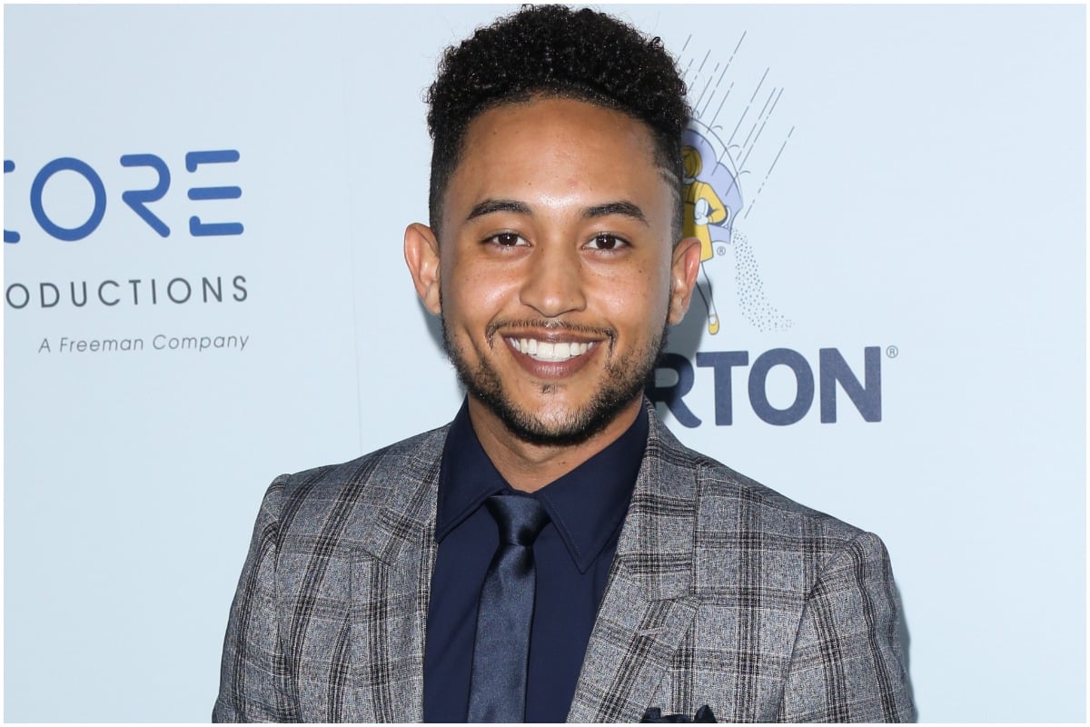 'Smart Guy' actor Tahj Mowry smiling while wearing a suit at a red carpet event.