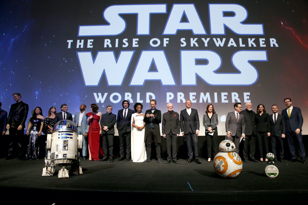 The cast and crew of 'Star Wars: The Rise of Skywalker' pose under a display of the movie's logo