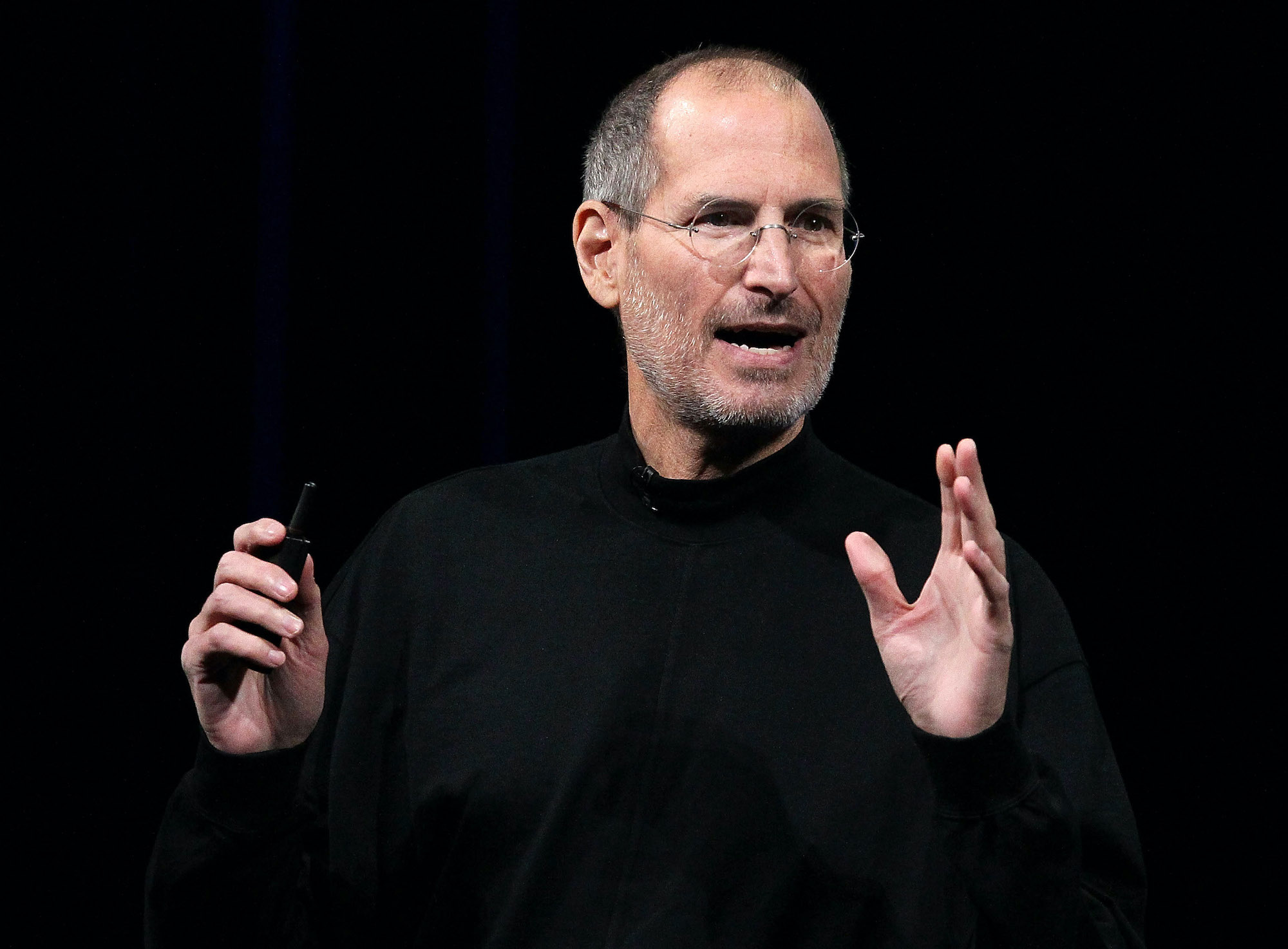 Steve Jobs speaking in front of a black background
