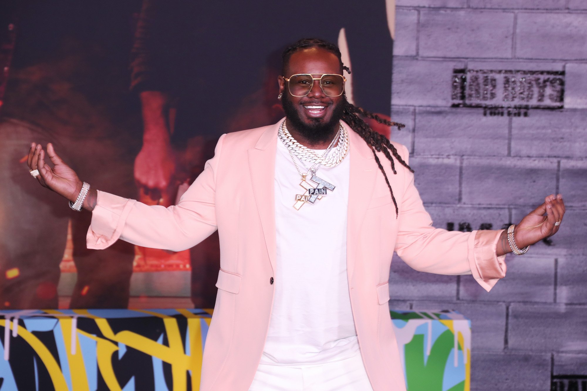 T-Pain shrugging with his arms outstretched