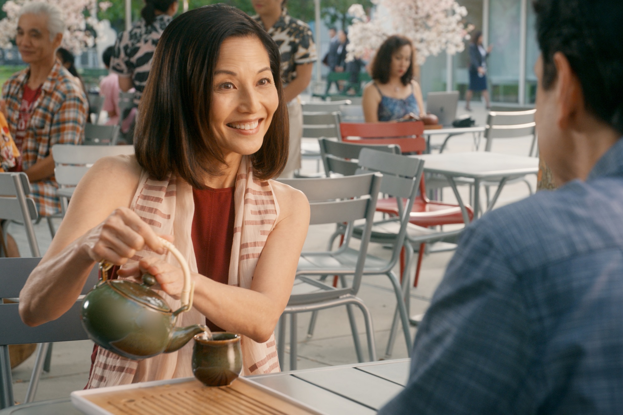 Tamlyn Tomita sits at a table outside