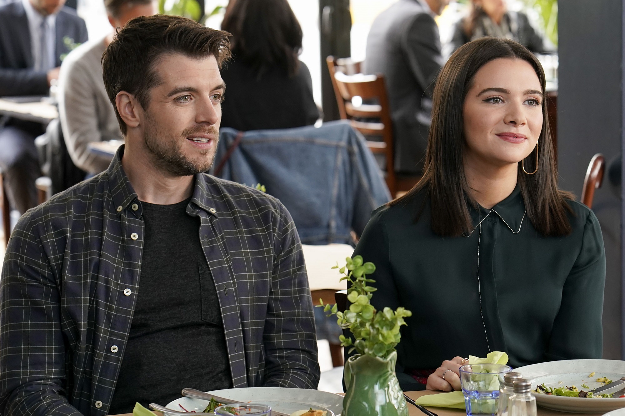 Ryan and Jane sit beside each other at a restaurant table in 'The Bold Type'