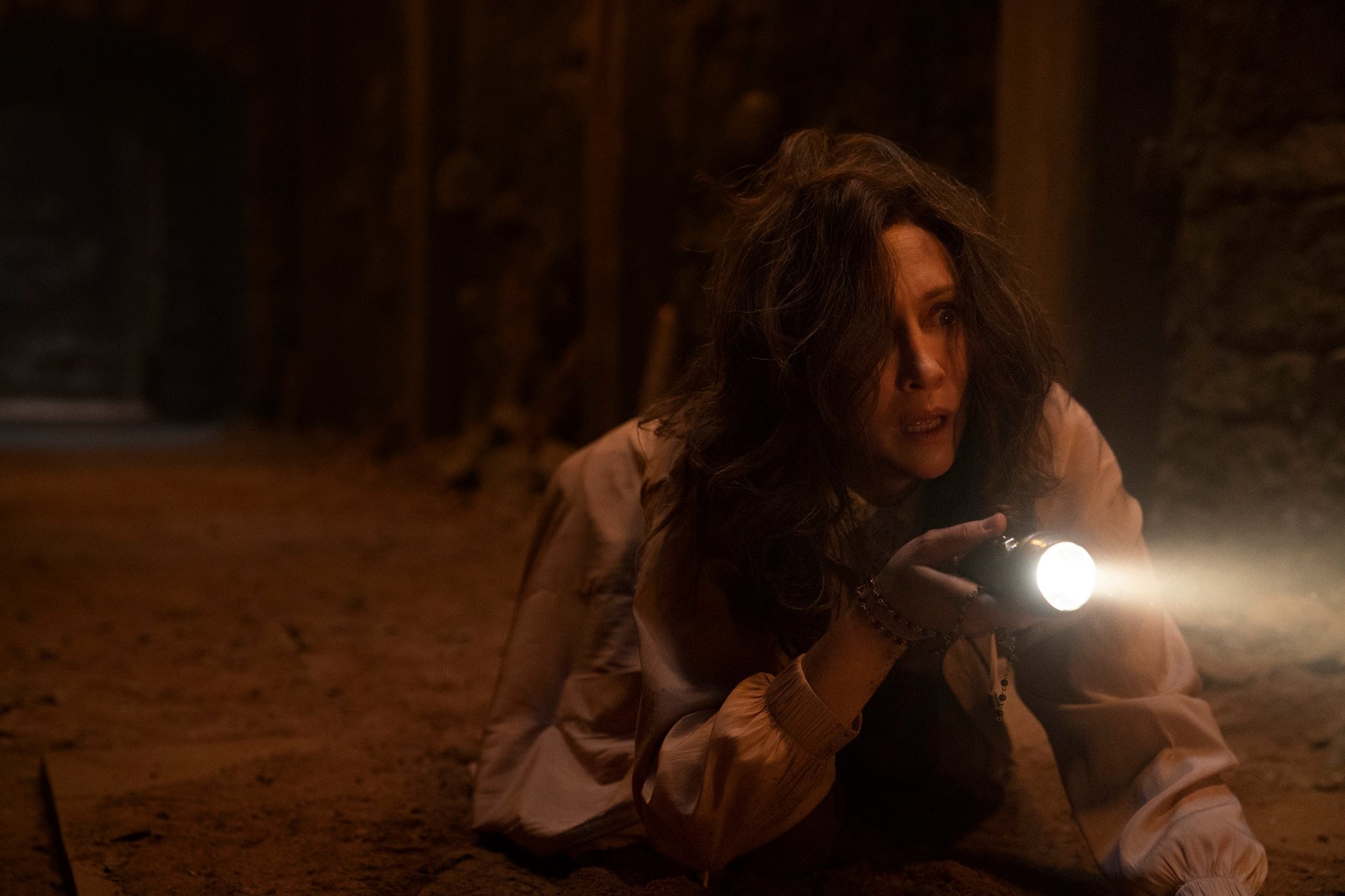 The Conjuring 3: Vera Farmiga holds a flashlight in the dark