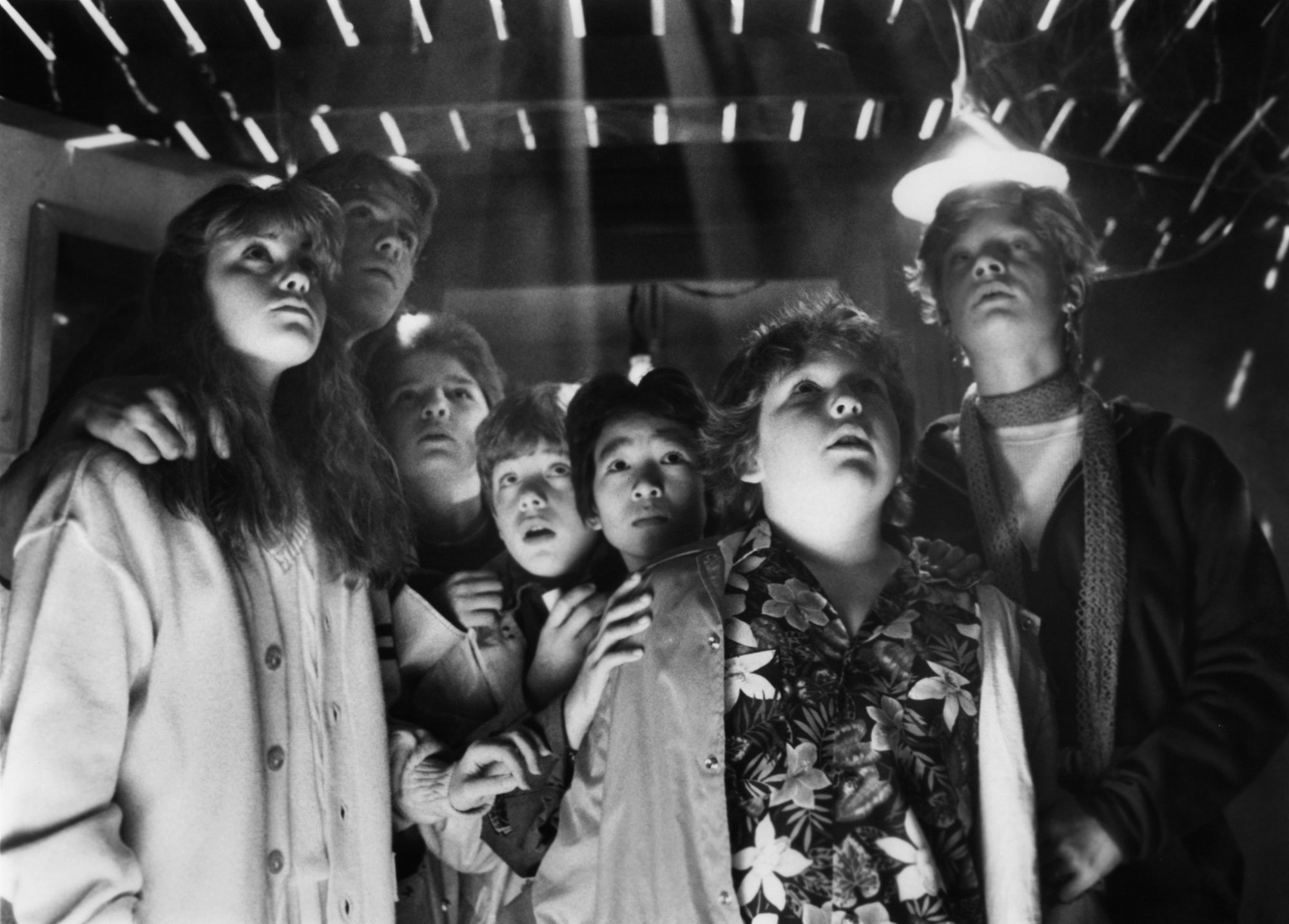 'The Goonies' cast members looking up, nervous, in black and white