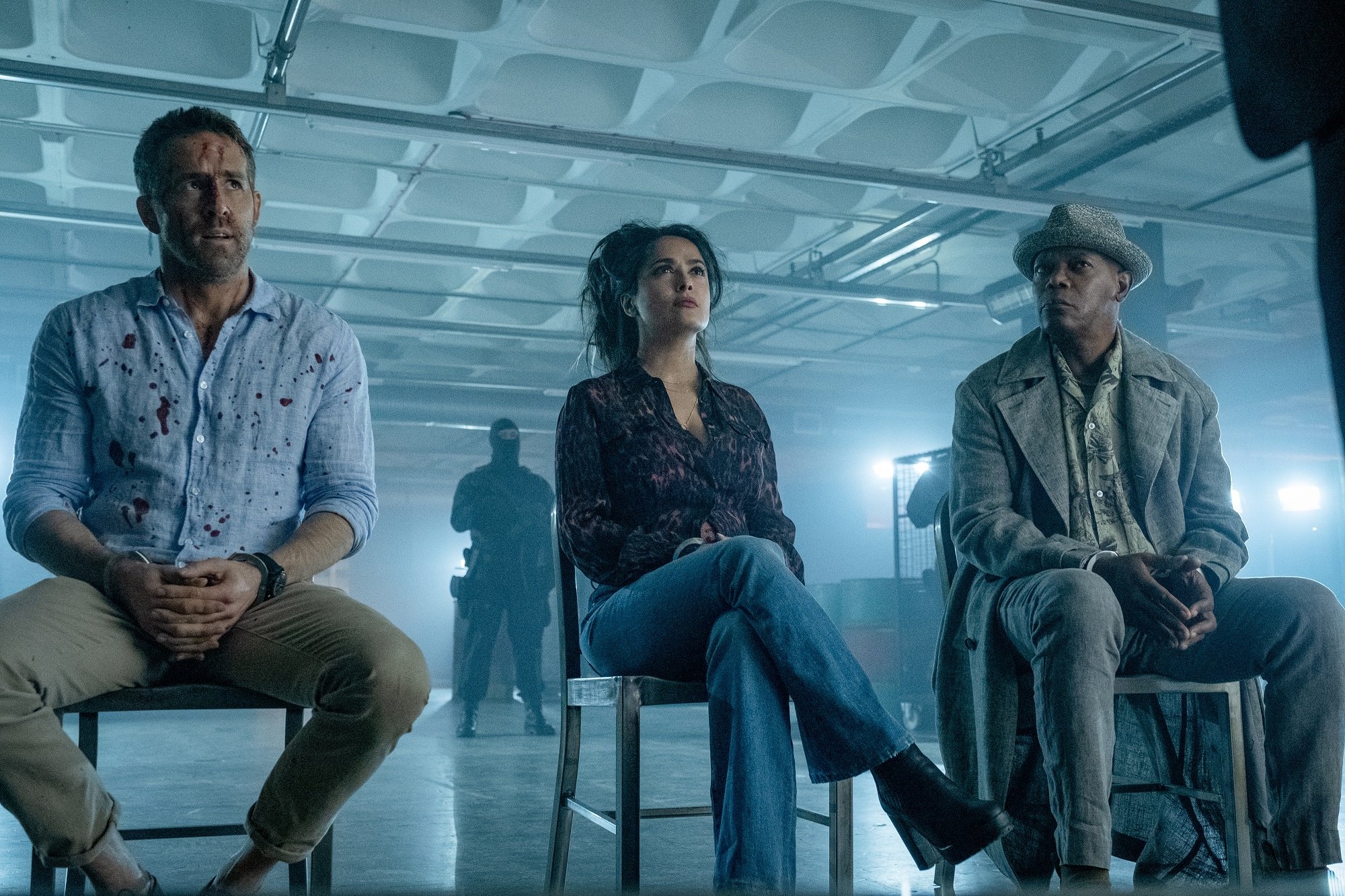 The Hitman's Wife's Bodyguard stars Ryan Reynolds, Salma Hayek and Samuel L. Jackson sit in chairs