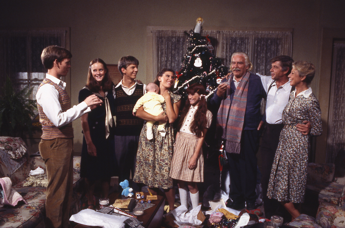 Members of the Walton family standing around a Christmas tree in a 1977 episode of The Waltons