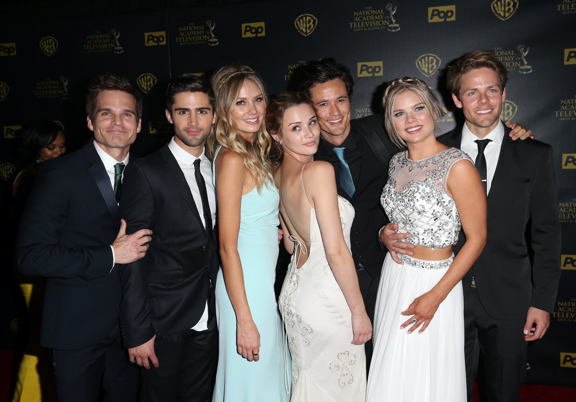 Cast members of 'The Young and the Restless' smiling in front of a black background