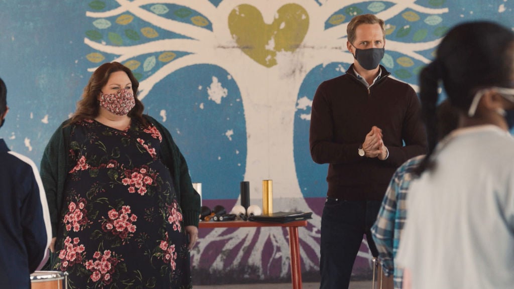 Chrissy Metz as Kate, Chris Geere as Phillip are masked as they stand in front of a crowd.